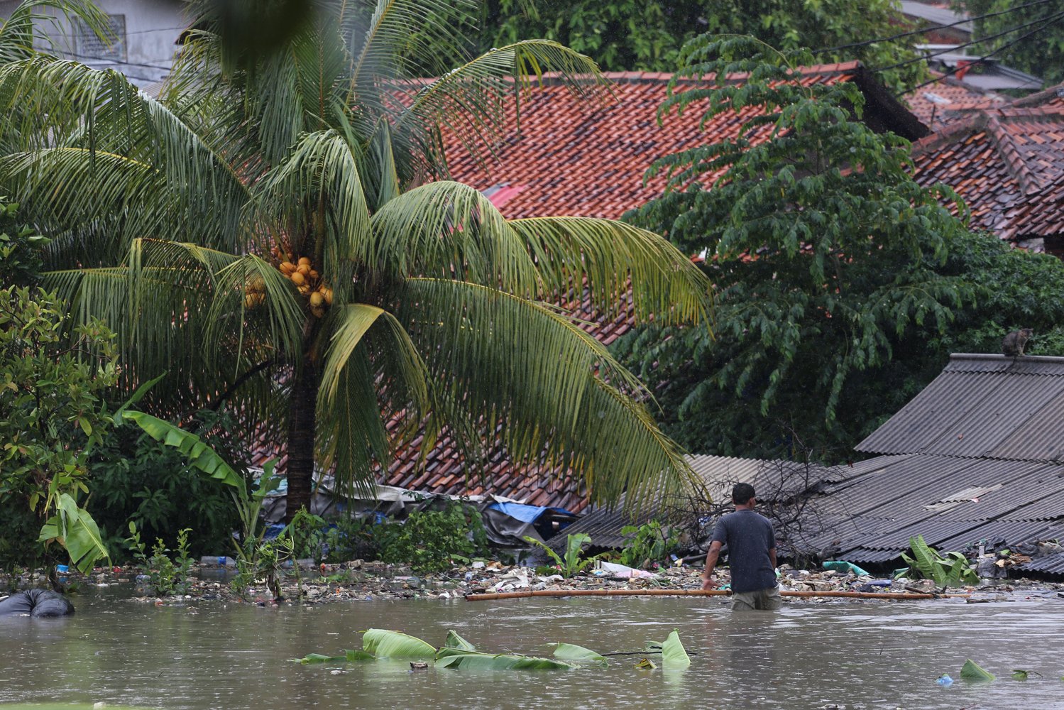 Seorang warga membersihkan sampah di rumah yang terkena banjir di Poris, Kota Tangerang, Banten, Rabu (1/1/2020). Hujan lebat yang mengguyur sejak malam hari menyebabkan beberapa titik di Tangerang terendam banjir. 