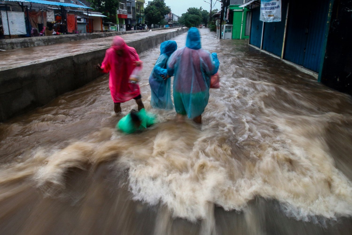Warga melintasi banjir yang menggenangi Perumahan Pondok Maharta, Pondok Kacang, Tangerang Selatan, Banten, Kamis (1/1/2020). Banjir yang menggenangi permukiman warga tersebut disebabkan oleh tingginya curah hujan. Warga melintasi banjir yang menggenangi Perumahan Pondok Maharta, Pondok Kacang, Tangerang Selatan, Banten, Kamis (1/1/2020). Banjir yang menggenangi permukiman warga tersebut disebabkan oleh tingginya curah hujan.