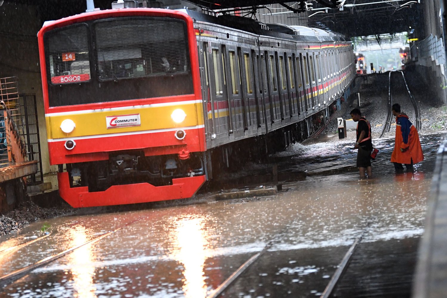 Salah satu rangkaian KRL Commuterline melintas perlahan pada jalur rel yang terendam banjir di Stasiun KA Sudirman, Menteng, Jakarta, Rabu (1/1/2020). Banjir yang menggenangi sejumlah titik pada jalur rel di Jakarta berdampak pada gangguan pelayanan sejumlah rute KRL Commuterline Jabodetabek. 