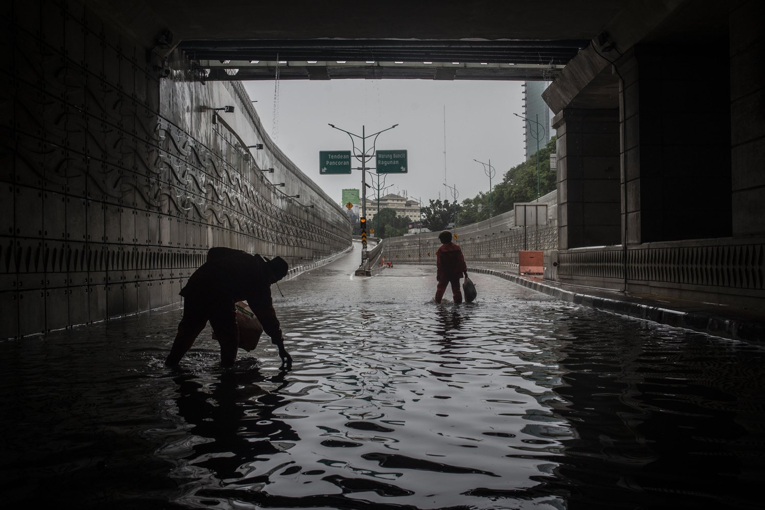 Petugas PPSU memberishkan sampah saat terjadi genangan banjir di Underpass Mampang-Kuningan, Jakarta, Rabu (1/1/2020). Banjir tersebut disebabkan karena tingginya intensitas hujan yang mengguyur sejak Selasa (31/12/2019). 