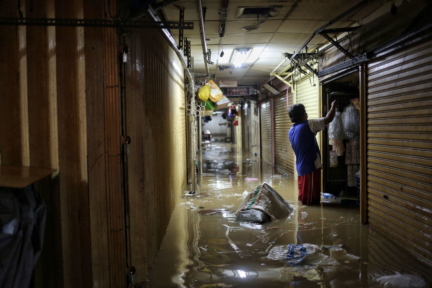 Pedagang memindahkan barang dagangan akibat banjir yang menggenangi lantai dasar Pasar Jatinegara, Jakarta, Kamis (2/1/2020). Berdasarkan data Badan Nasional Penanggulangan Bencana (BNPB) per 2 Januari 2020, terdapat 63 titik banjir di wilayah DKI Jakarta dan secara keseluruhan terdapat 169 titik banjir untuk wilayah Jabodetabek dan Banten. 