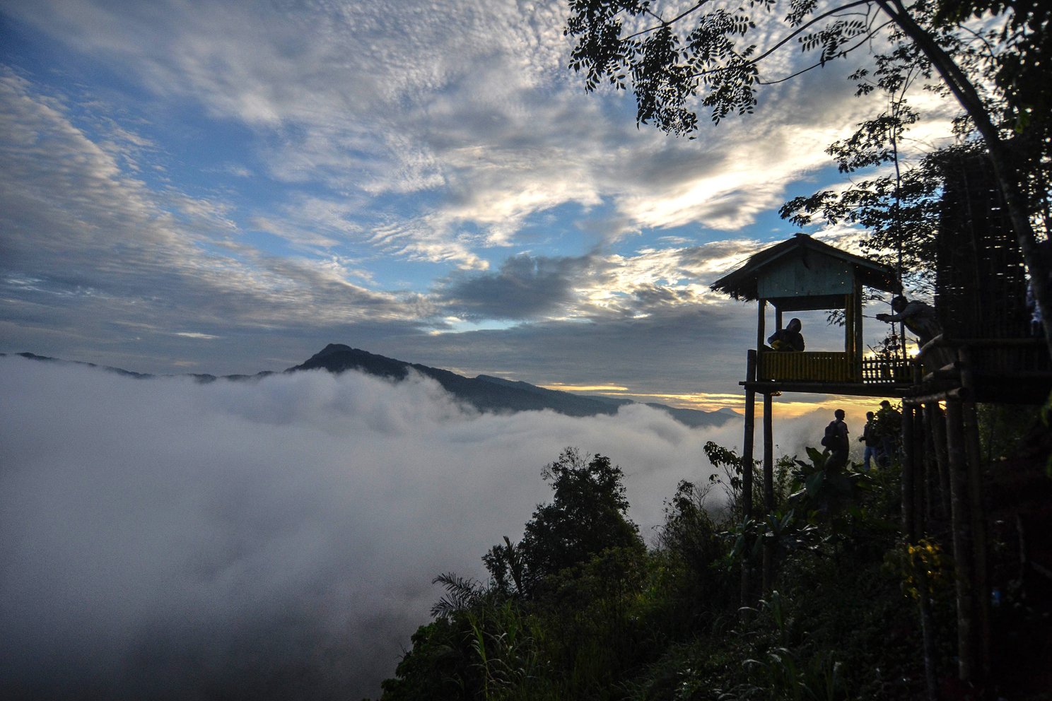 Pengunjung menikmati pemandangan dari Puncak Bangku, Desa Situmandala, Kecamatan Rancah, Kabupaten Ciamis, Jawa Barat, Minggu (29/12/2019). Wisata pemandangan dan kabut tebal yang menyelimuti Gunung Potaka dan Ranto tersebut dikelola secara swadaya oleh masyarakat setempat. 