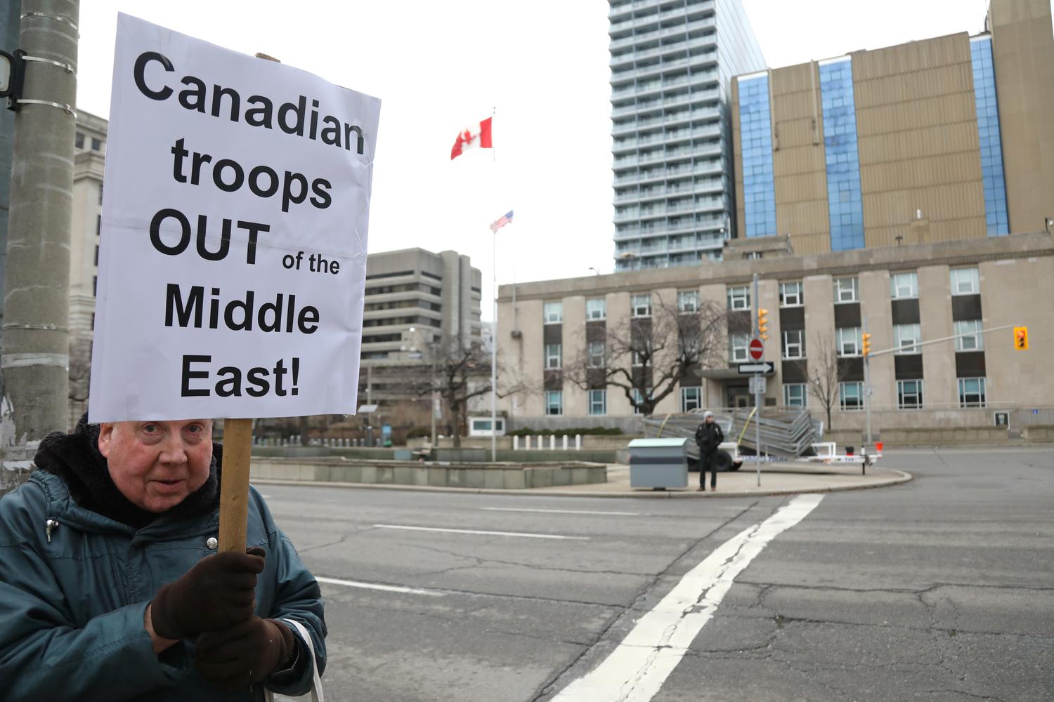 Seorang demonstran membawa papan tanda menyeru Kanada untuk menarik pasukannya dari Timur Tengah, saat aksi protes menentang perang di tengah meningkatnya ketegangan antara Amerika Serikat dengan Iran, di depan konsulat AS di Toronto, Ontario, Kanada, Sabtu (4/1/2020).