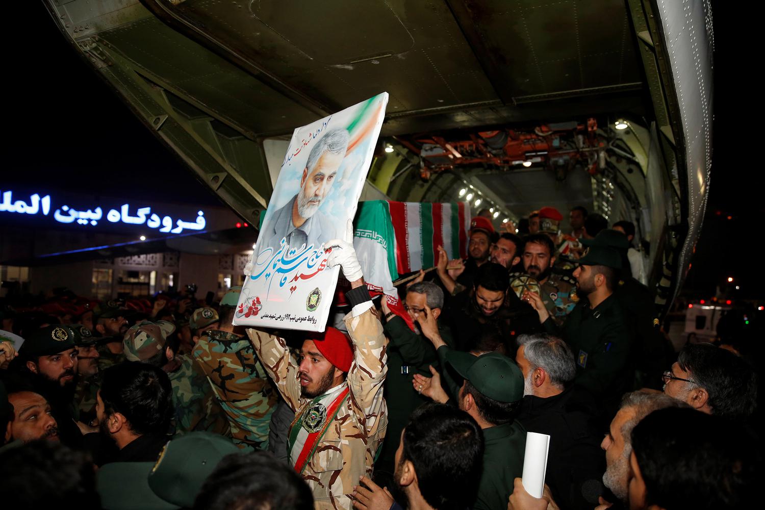 AWW Warga Iran mengangkat peti jenazah Mayor Jenderal Qassem Soleimani, kepala Pasukan elit Quds, yang tewas dalam serangan udara di bandara Baghdad, di bandara internasional Ahvaz, di Ahvaz, Iran, Minggu (5/1/2020).