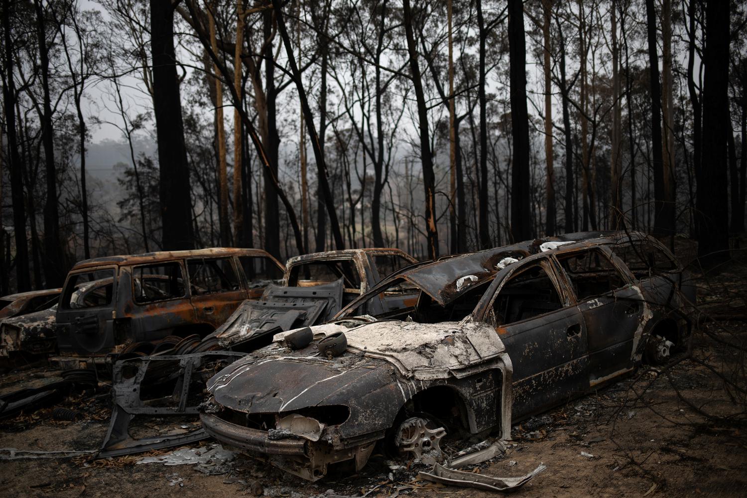 Sejumlah mobil hangus terbakar dekat wilayah kebakaran hutan di desa Mogo, Australia, Rabu (8/1/2020).
