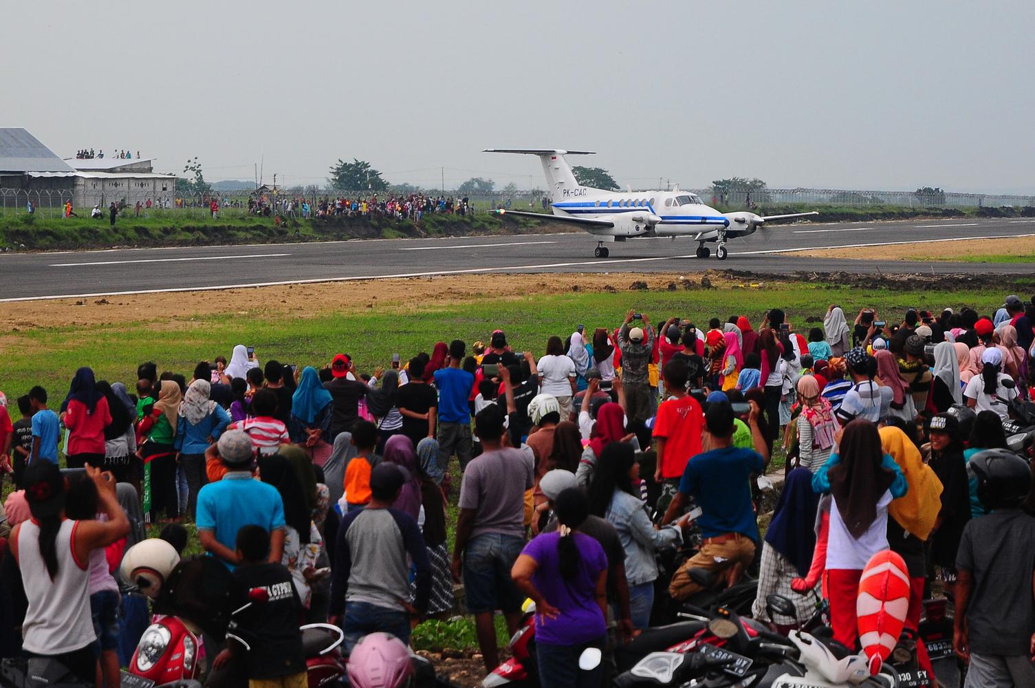 Warga menyaksikan pendaratan pesawat King Air 200GT saat pendaratan perdana di Bandara Ngloram, Cepu, Blora, Jawa Tengah, Sabtu (11/1/2020).