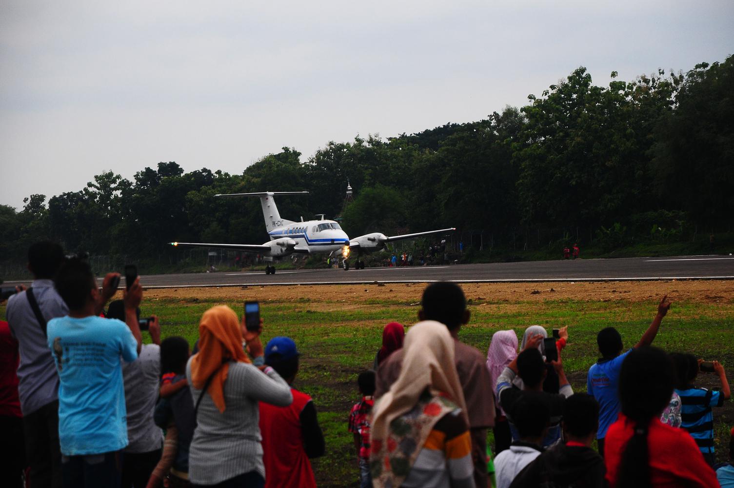 Warga menyaksikan pendaratan pesawat King Air 200GT saat pendaratan perdana di Bandara Ngloram, Cepu, Blora, Jawa Tengah, Sabtu (11/1/2020). 
