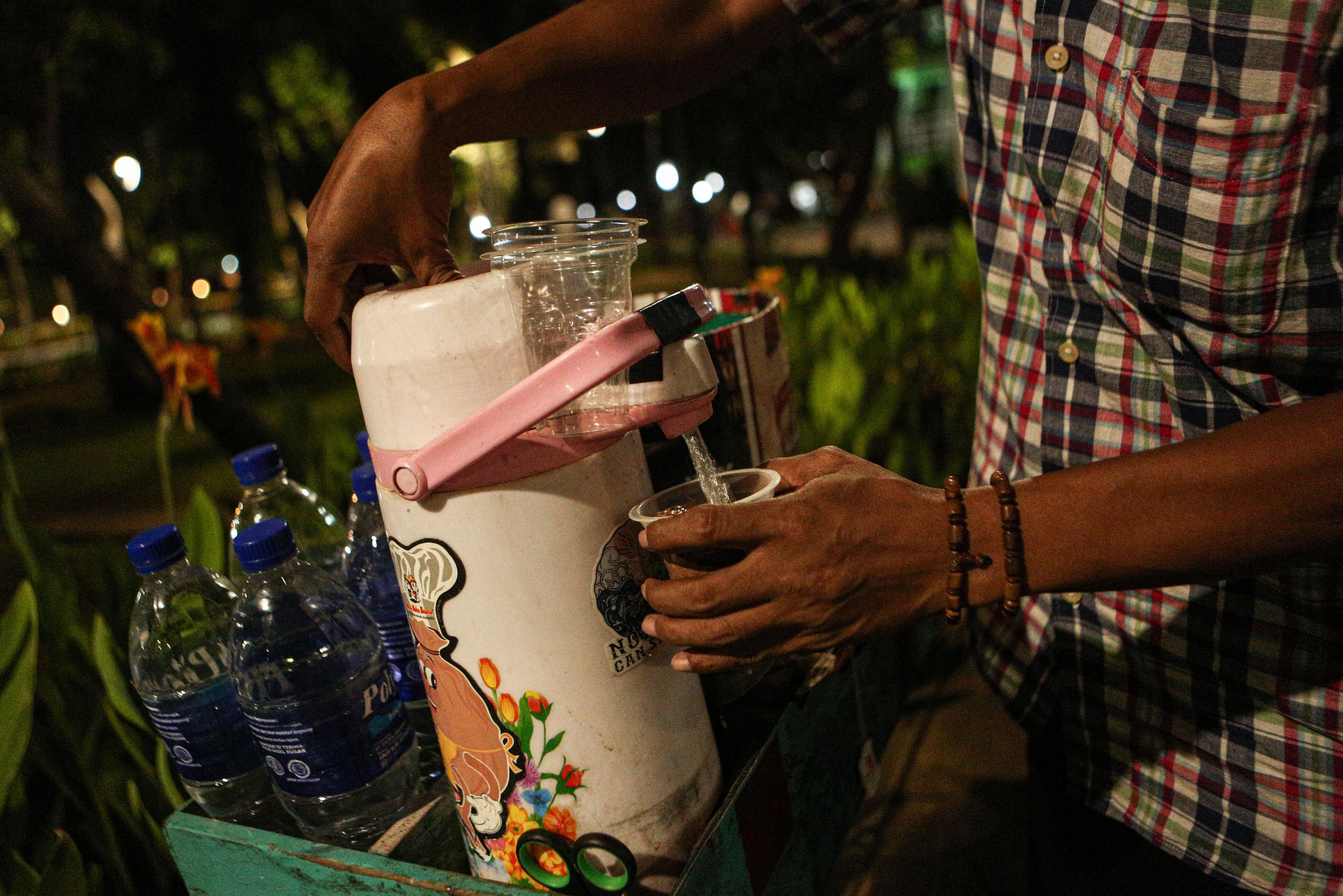 Hendra (30), menyiapkan kopi untuk pembeli di Kawasan Taman Menteng, Jakarta Pusat.