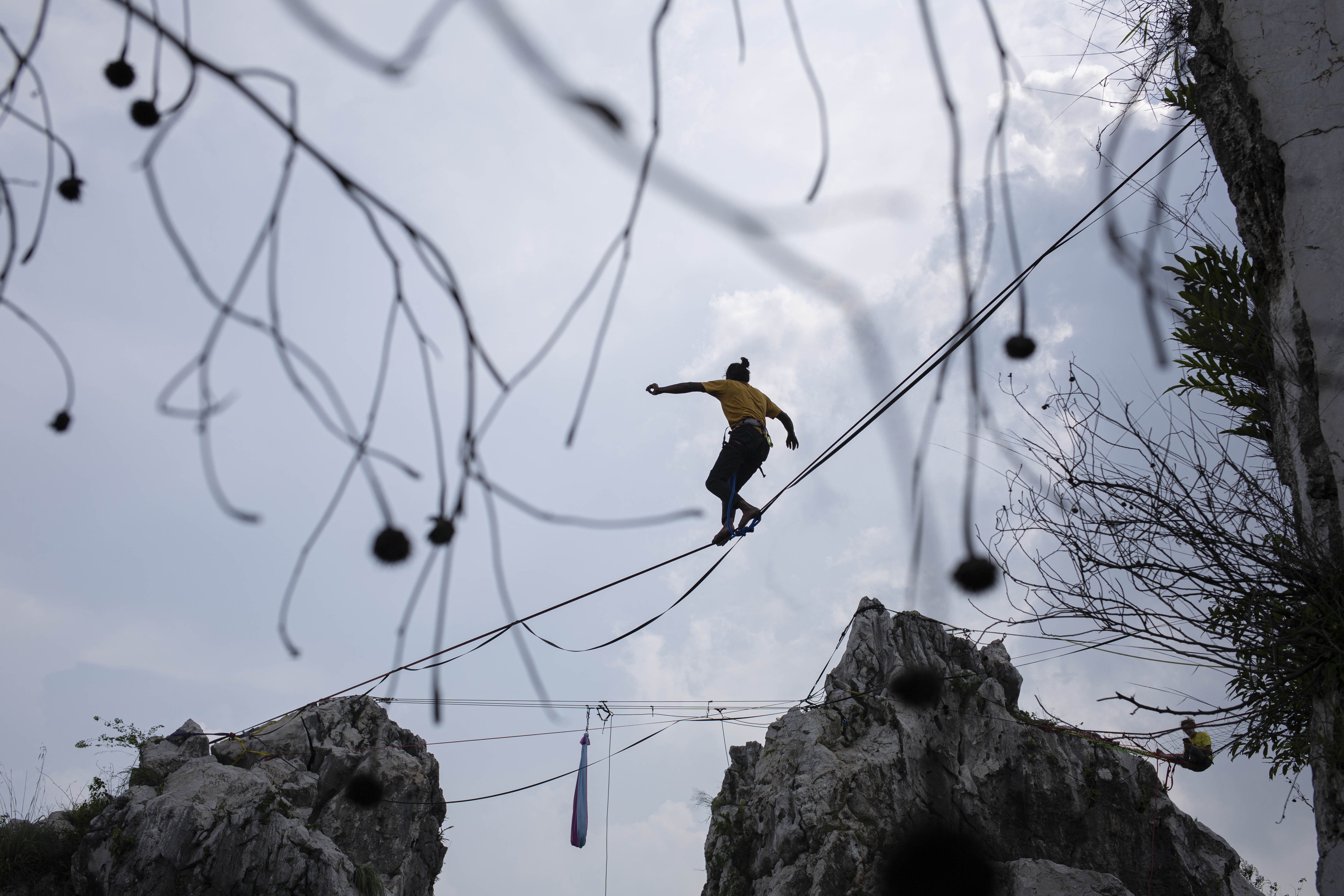 Dadeng, menjaga keseimbangan di atas tali saat melakukan aksi highline di Tebing Gunung Hawu, Padalarang, Kabupaten Bandung Barat.