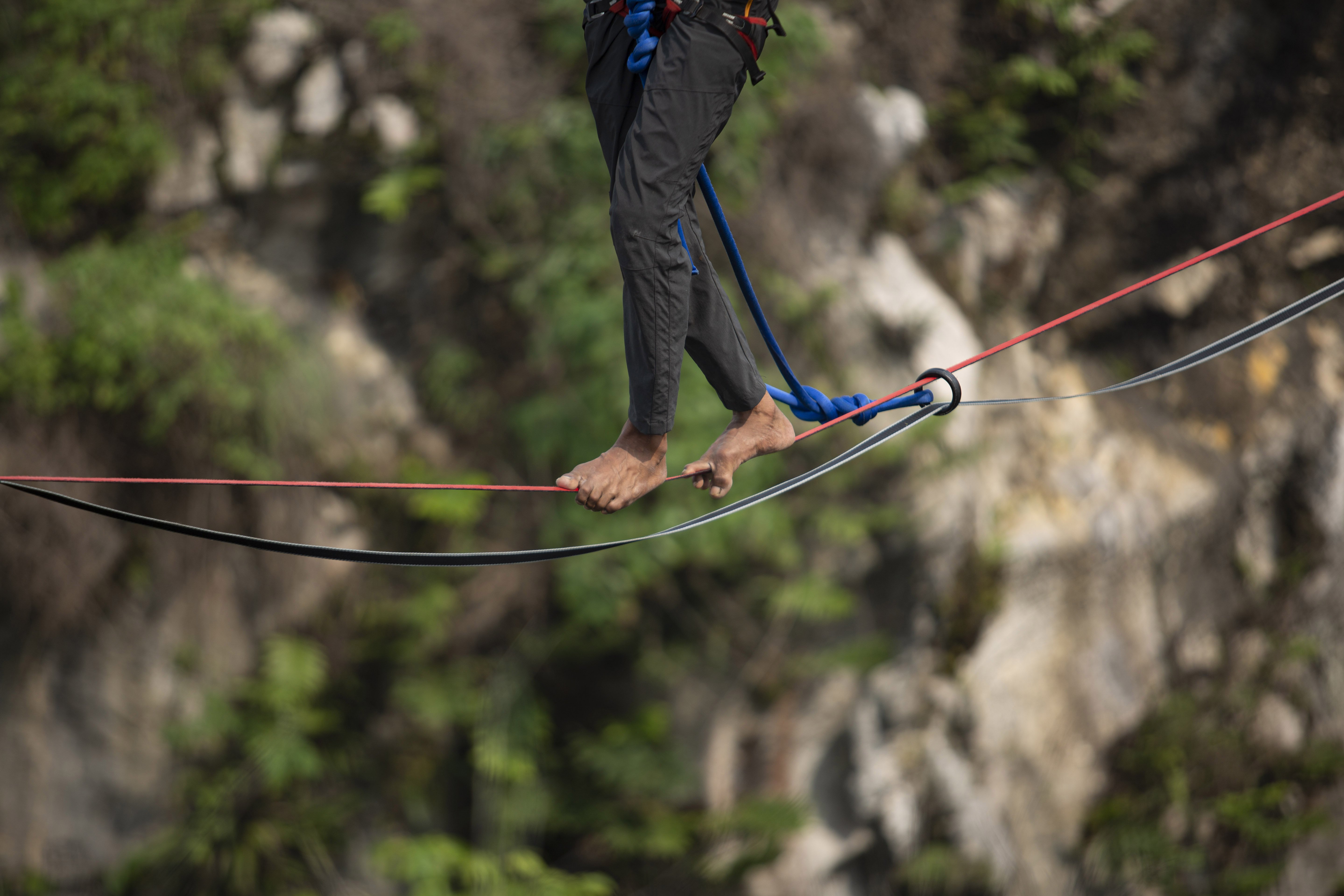 Dadeng, menjaga keseimbangan di atas tali saat melakukan aksi highline di Tebing Gunung Hawu, Padalarang, Kabupaten Bandung Barat.