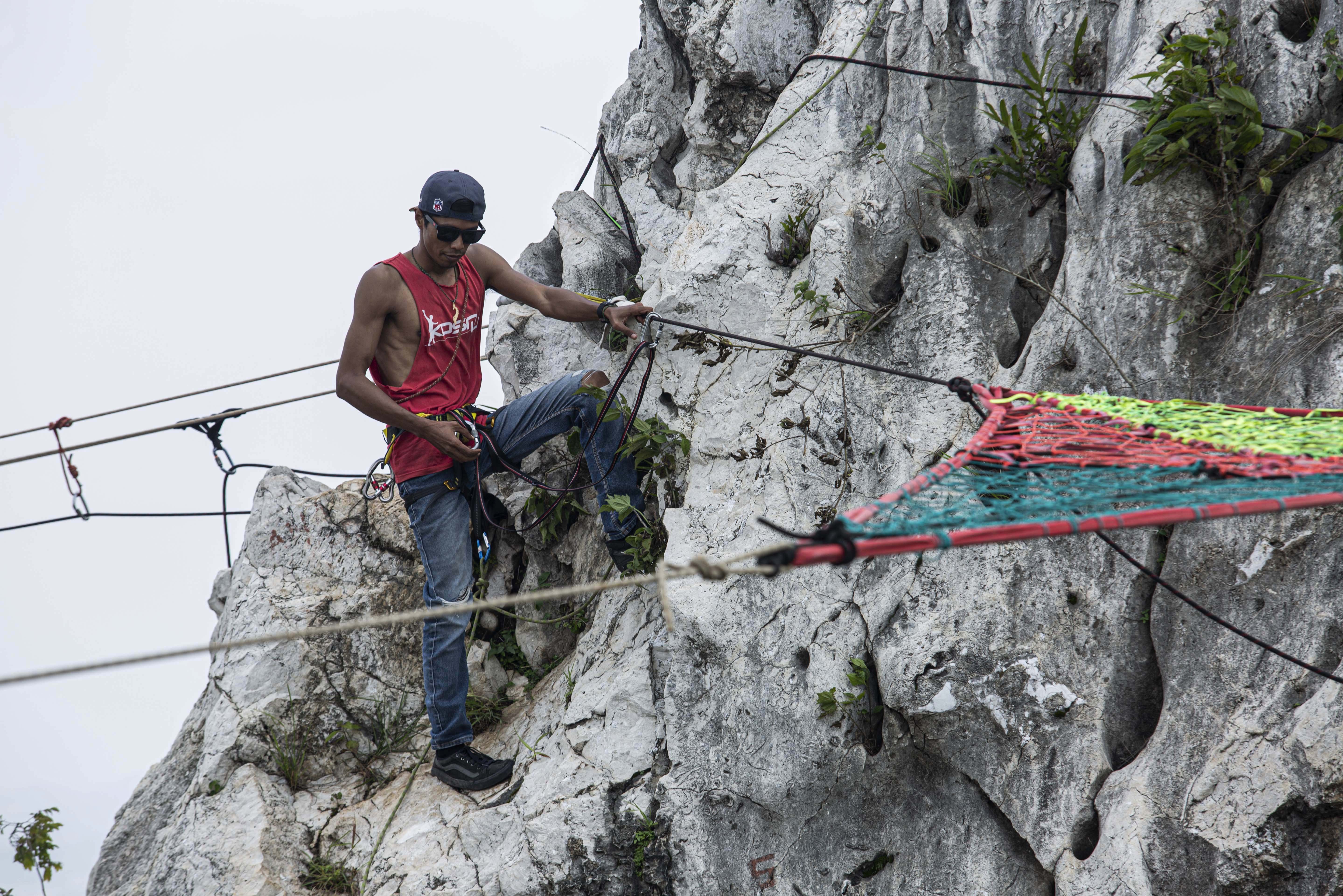 Anggota pengiat olahraga ekstrim Pushing Panda memasang tali pemangan highline di Tebing Gunung Hawu, Karst Citatah, Padalarang, Kabupaten Bandung Barat. \r\n