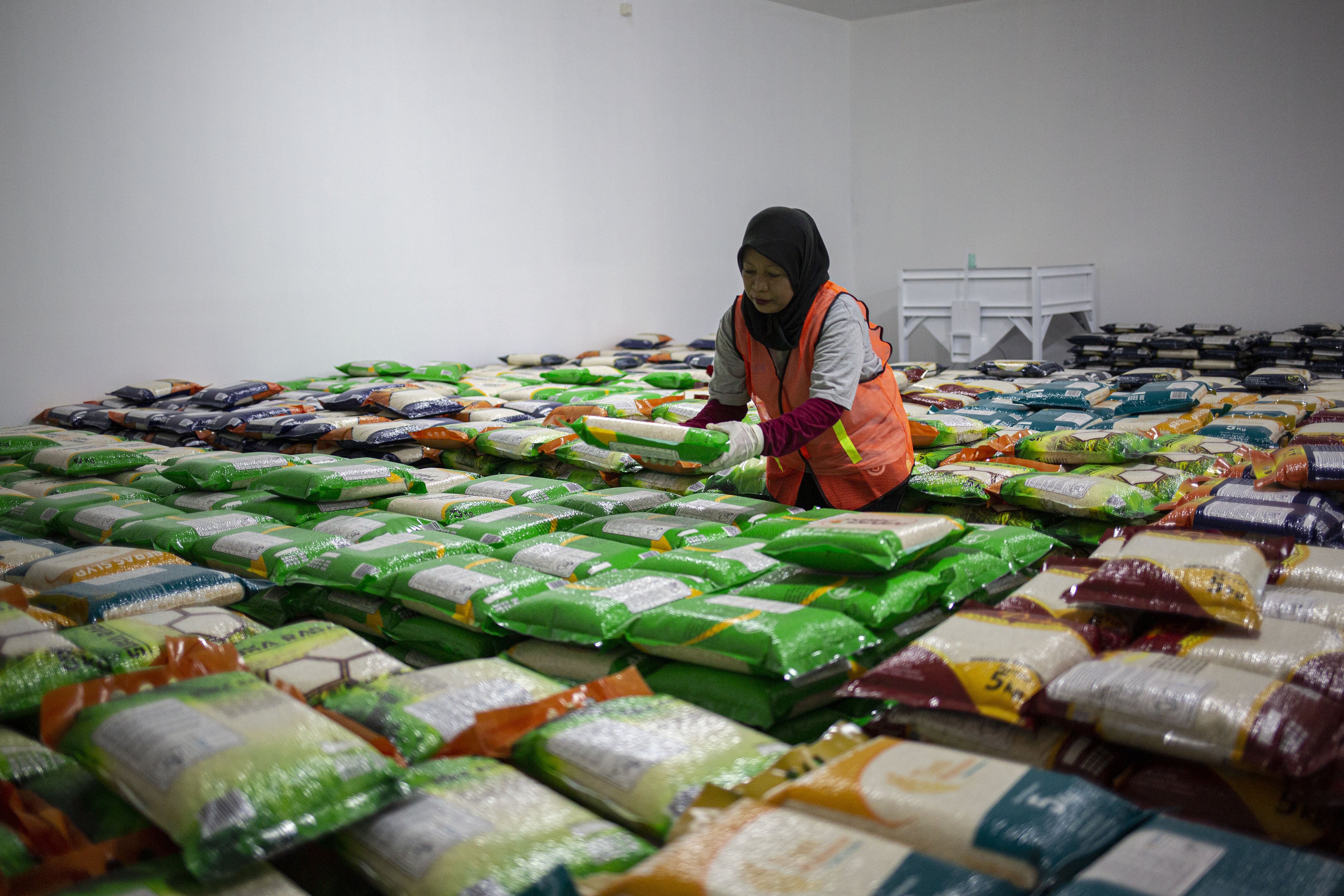 Pekerja merapihkan beras yang telah dikemas di Gudang Bulog, Kelapa Gading, Jakarta Utara, Kamis (27/2/2020). Jelang Ramadhan dan Idul Fitri 2020 pasokan beras di seluruh wilayah Indonesia akan tercukupi dengan menyediakan 1,7 juta ton beras.
