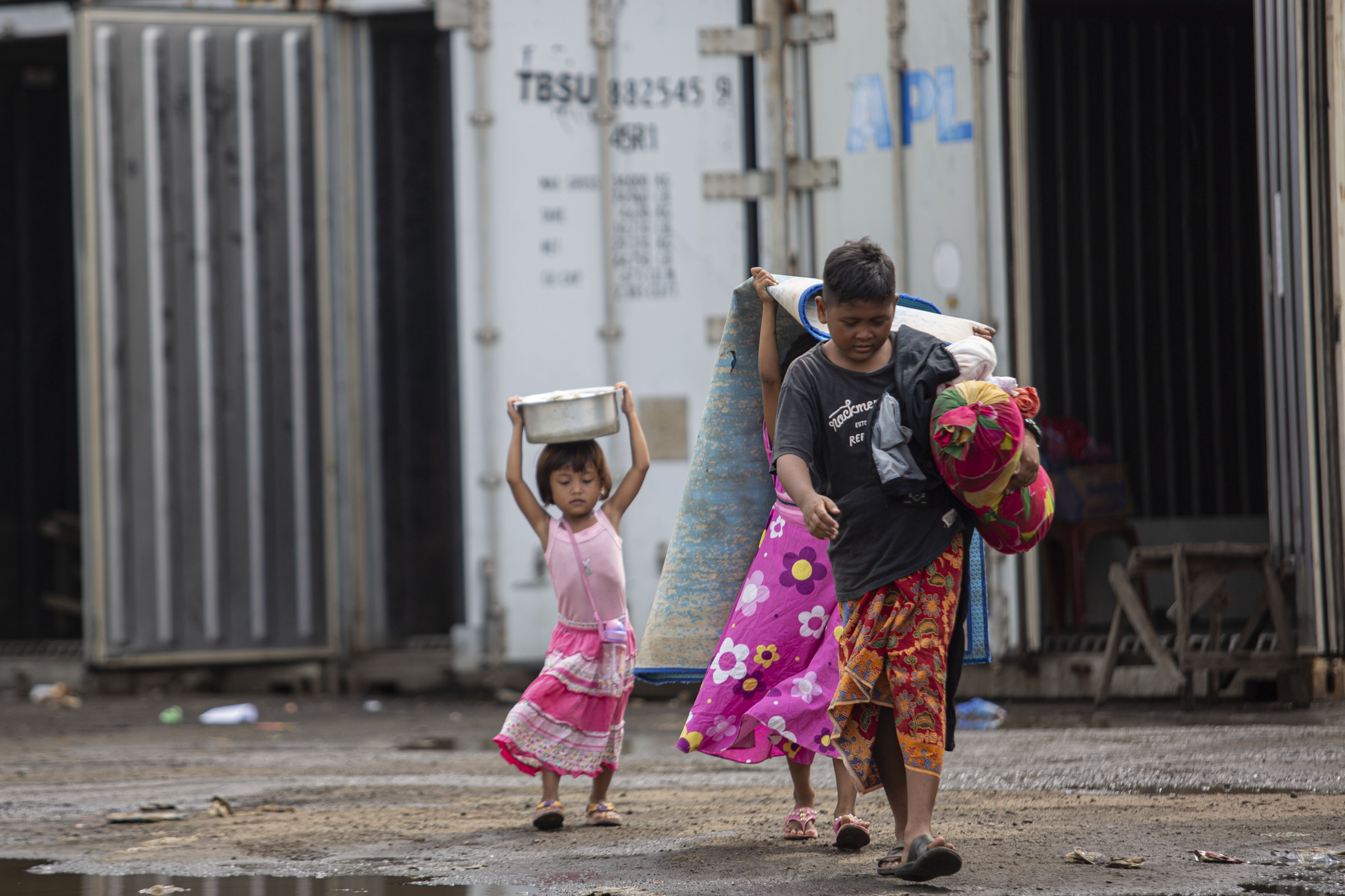 Sejumlah anak membawa perlengkapan tidur unuk mengungsi di dalam peti kemas kosong di Kampung Sepatan, Rorotan, Jakarta Utara, Kamis (27/2/2020). Sebanyak 419 warga Kampung Sepetan mengungsi di dalam peti kemas kosong dari hari Minggu (23/2/2020) dini hari setelah rumahnya tergenang banjir setinggi 1,5 meter.