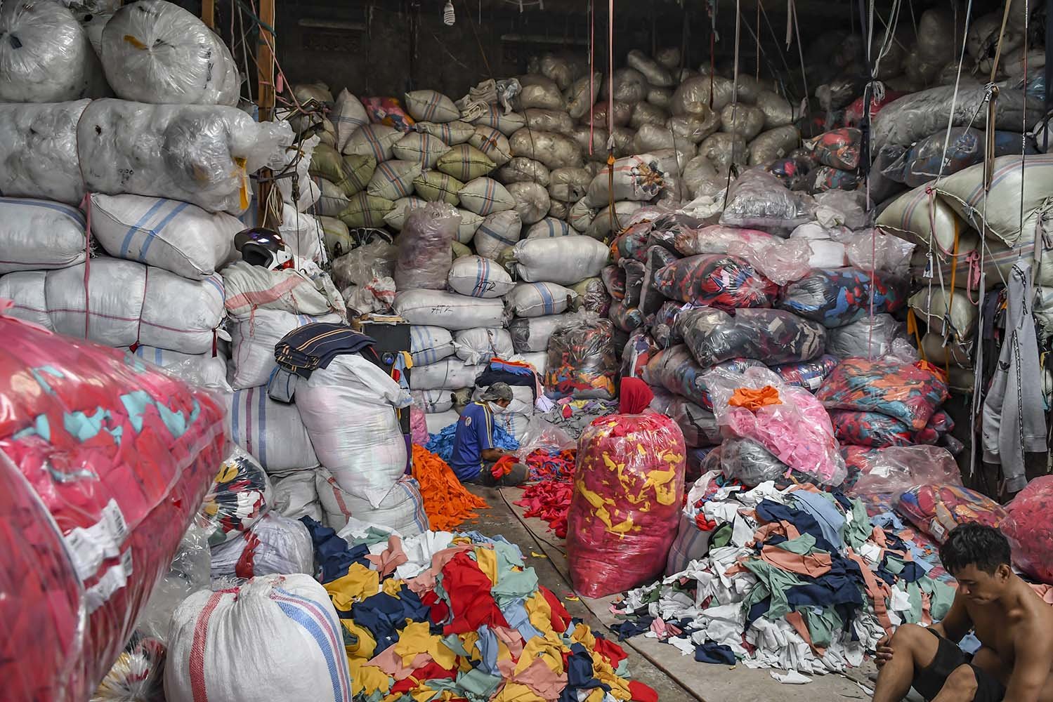 Pekerja memilah limbah sisa kain di tempat pengepul limbah tekstil, Jakarta. 