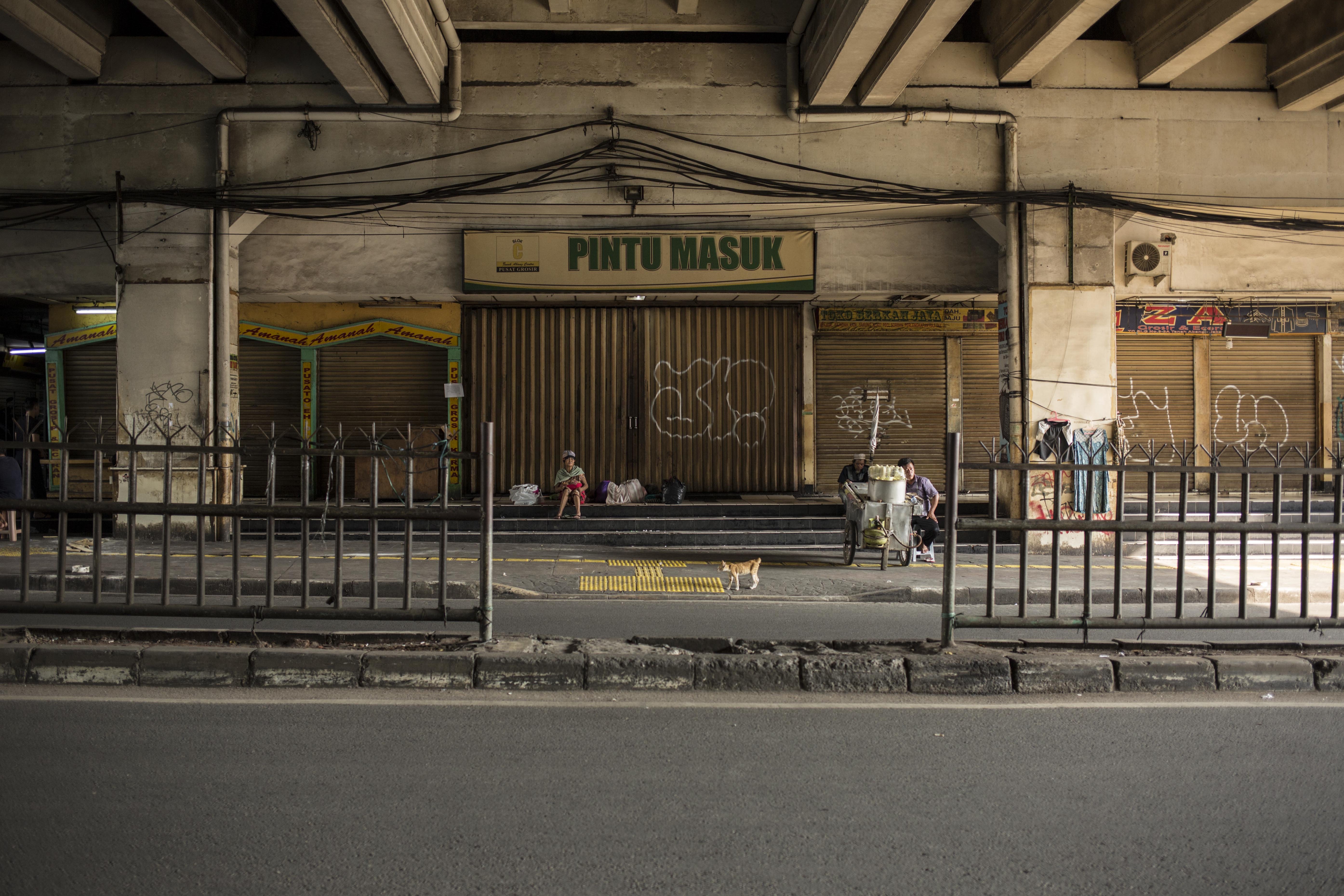 Warga beraktivitas di depan Pasar Tanah Abang Blok A yang tutup di Jakarta, Jumat (27/3/2020). Dalam rangka pencegahan dan menekan angka penularan virus Corona (COVID-19), Perumda Pasar Jaya menutup sementara Pasar Tanah Abang Blok A, B dan F mulai 27 Maret hingga 5 April 2020.