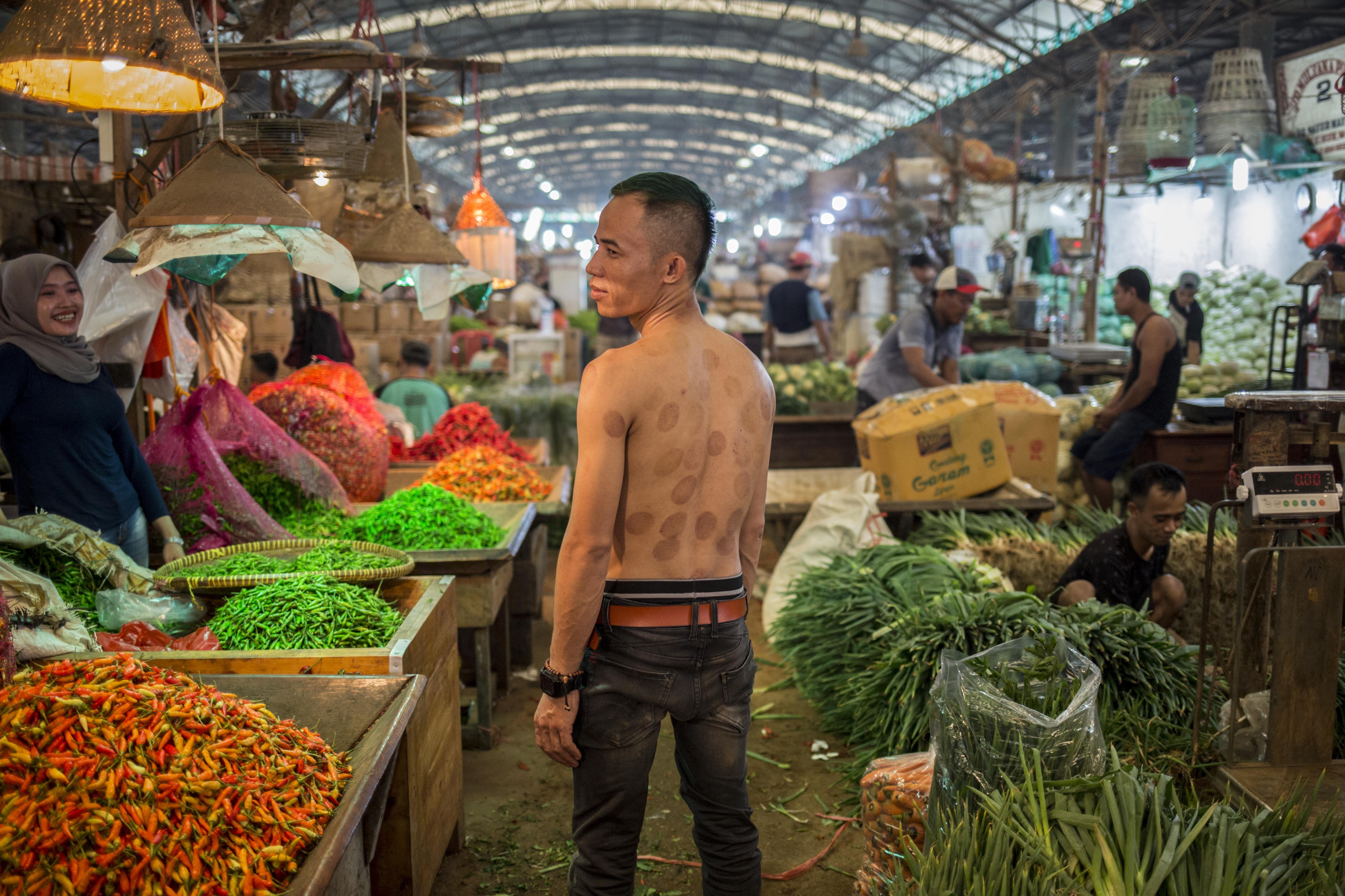 Muhammad Yusuf (32), pedagang asal Sukabumi yang berjualan di Pasar Induk Kramat Jati, Jakarta Timur yang harus tetap berjualan guna menafkahi keluarga di kampung halaman.