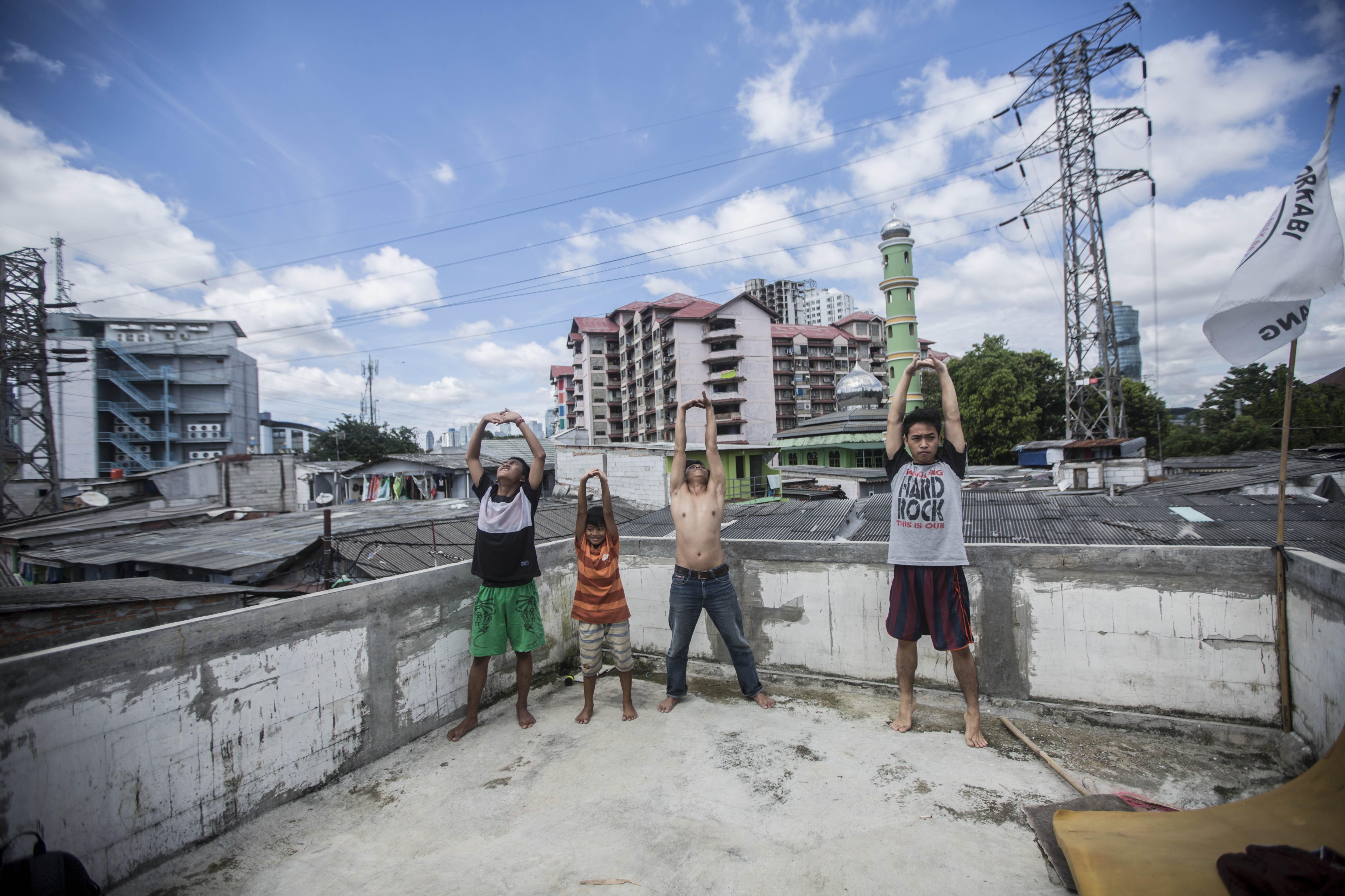 Sejumlah warga berjemur di balkon kawasan pemukiman Penjompongan, Jakarta Pusat, Selasa (7/4/2020). Berjemur diri di bawah sinar matahari di antara pukul 08.00 WIB-11.00 WIB dipercaya warga salah satu upaya yang paling sederhana untuk menjaga kesehatan selama wabah virus corona.