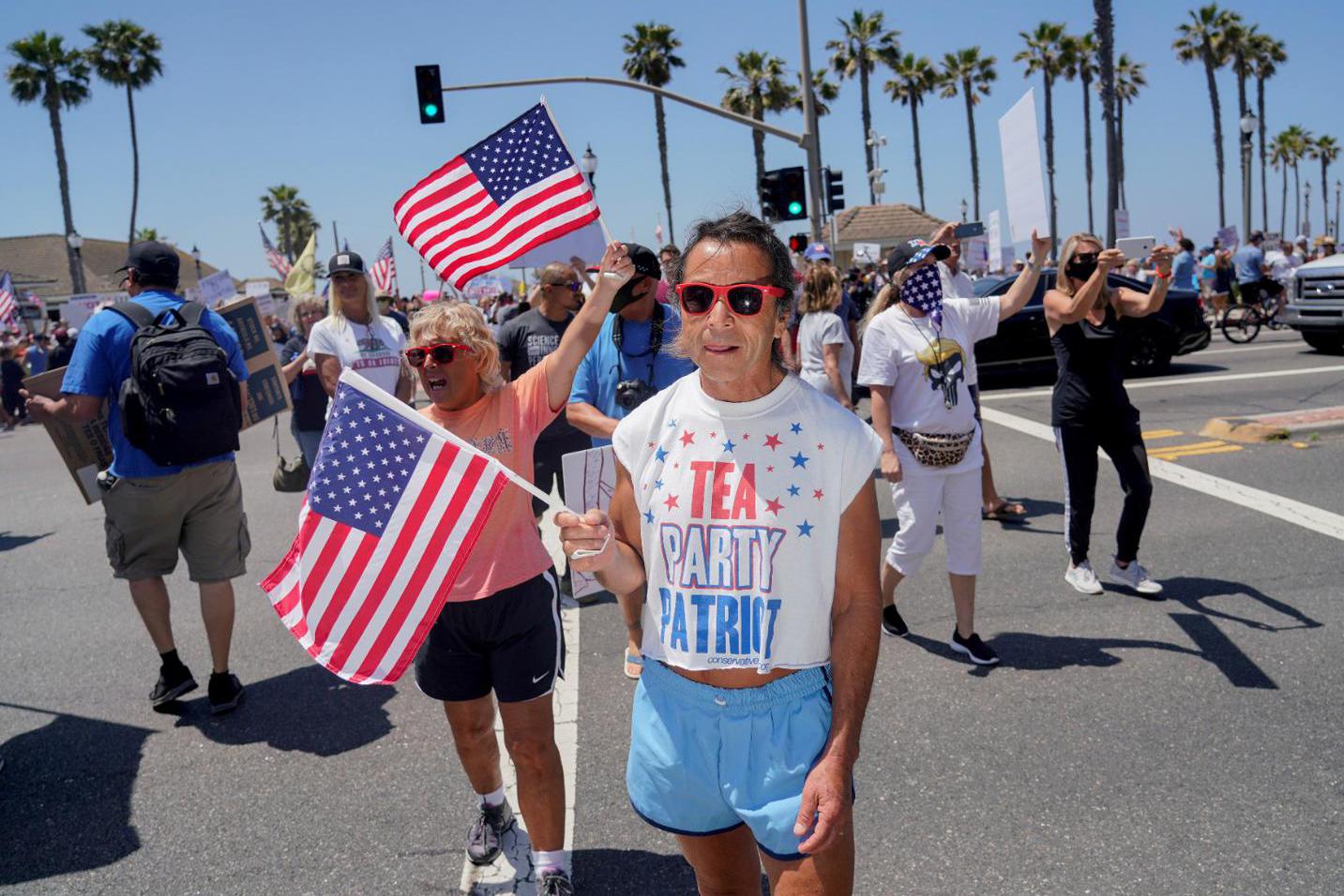 Kyle Grillot Warga berkumpul dekat Dermaga Pantai Huntington untuk memprotes perintah Gubernur Gavin Newsom untuk menutup sementara pantai di seluruh negara bagian dan Orange County, ditengah pandemi global virus corona (COVID-19), di Pantai Huntington, California, Amerika Serikat, Jumat (1/5/2020).