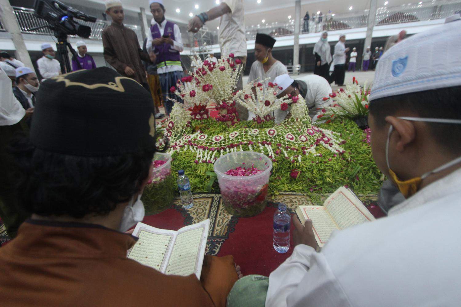 Santri membaca Al Quran di makam KH Ahmad Zuhdiannoor atau Guru Zuhdi di Aula Majta di dekat rumah duka di Banjarmasin, Kalimantan Selatan, Sabtu (2/5/2020). Proses pemakaman Guru Zuhdi tersebut hanya disaksikan oleh keluarga dan kerabat dekat saja untuk mencegah penyebaran COVID-19.