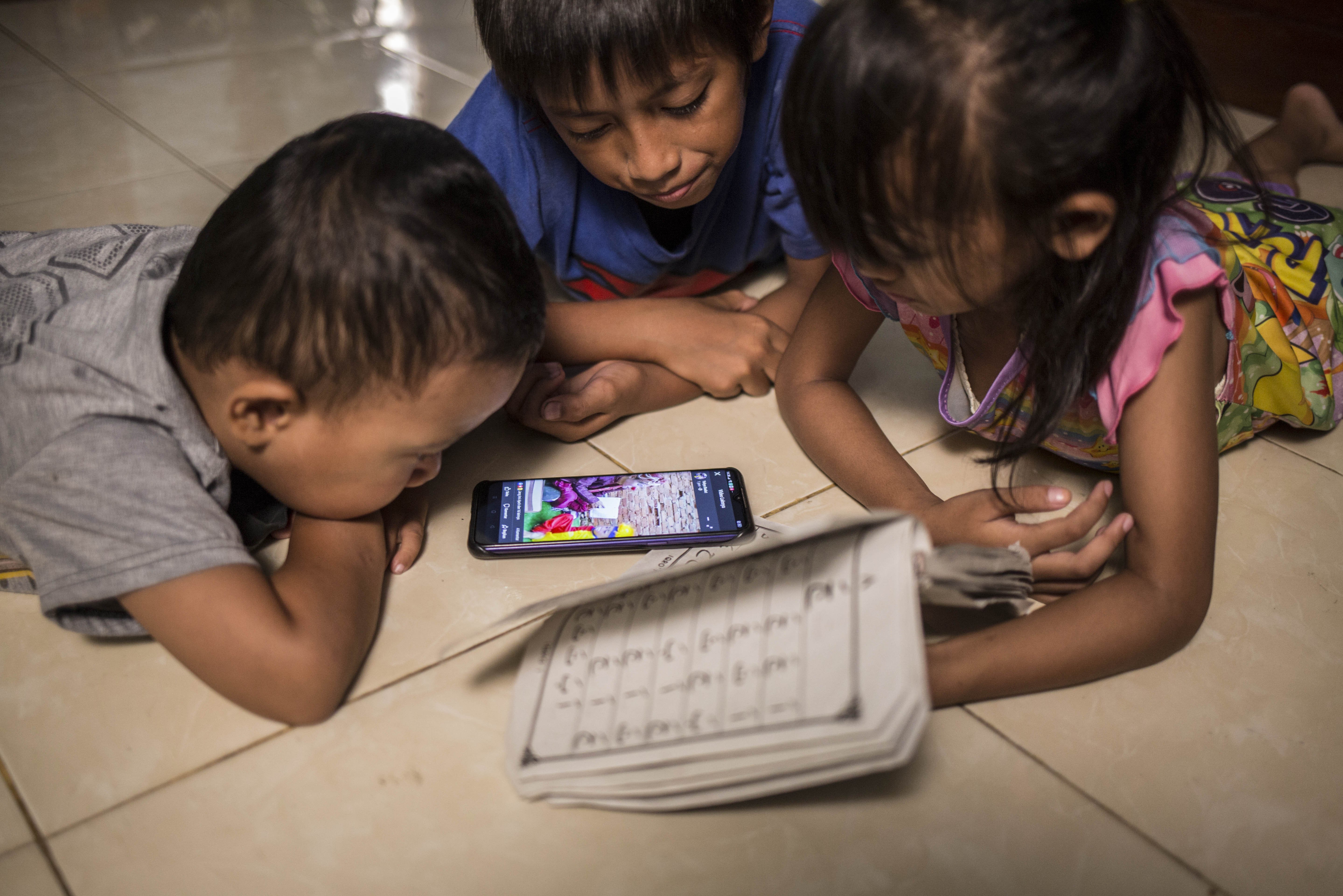 Anak-anak meyaksikan live streaming Badut Syar\'i di Kawasan Pinang, Kota Tangerang, Banten, Minggu (3/5/2020).
