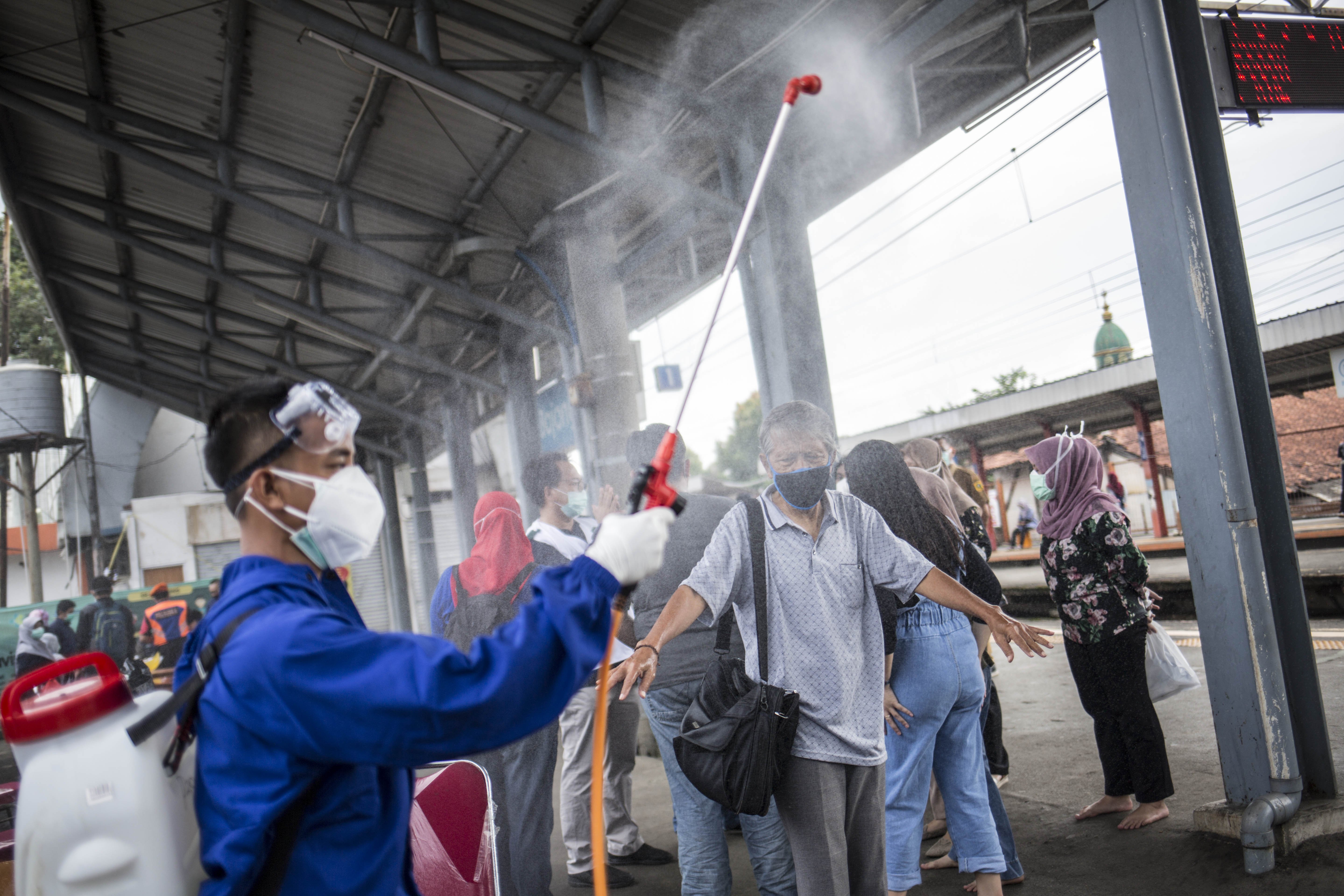 Petugas menyemprotkan disinfektan kepada penumpang KRL Commuter Line setelah melakukan swab tes masal Covid -19 di Stasiun Bojong Gede, Bogor, Jawa Barat, Senin (11/5). Tes swab tersebut dilakukan kepada 200 calon penumpang KRL secara acak sebagai salah satu langkah untuk mendeteksi dan mencegah penyebaran virus COVID-19 di transportasi umum.