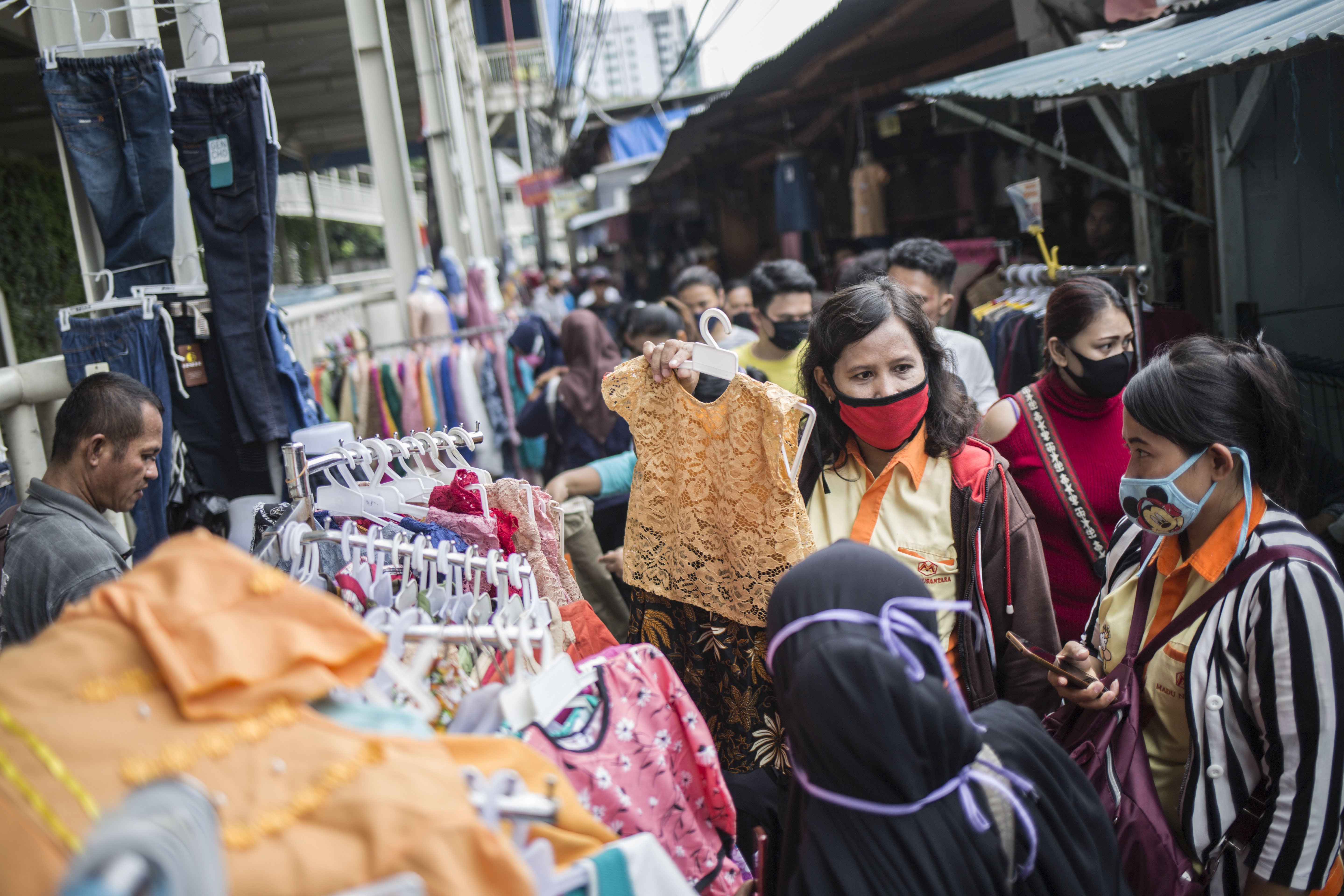 Warga berbelanja pakaian yang dijual pedagang kaki lima di atas trotoar Jalan Jati Baru Raya, Tanah Abang, Jakarta, Senin (18/5/2020). Meski kawasan niaga Pasar Tanah Abang telah tutup selama masa Pembatasan Sosial Berskala Besar (PSBB), namun sebagian pedagang tetap menggelar lapaknya di sejumlah titik seperti di atas trotoar dan di gang perkampungan setempat.
