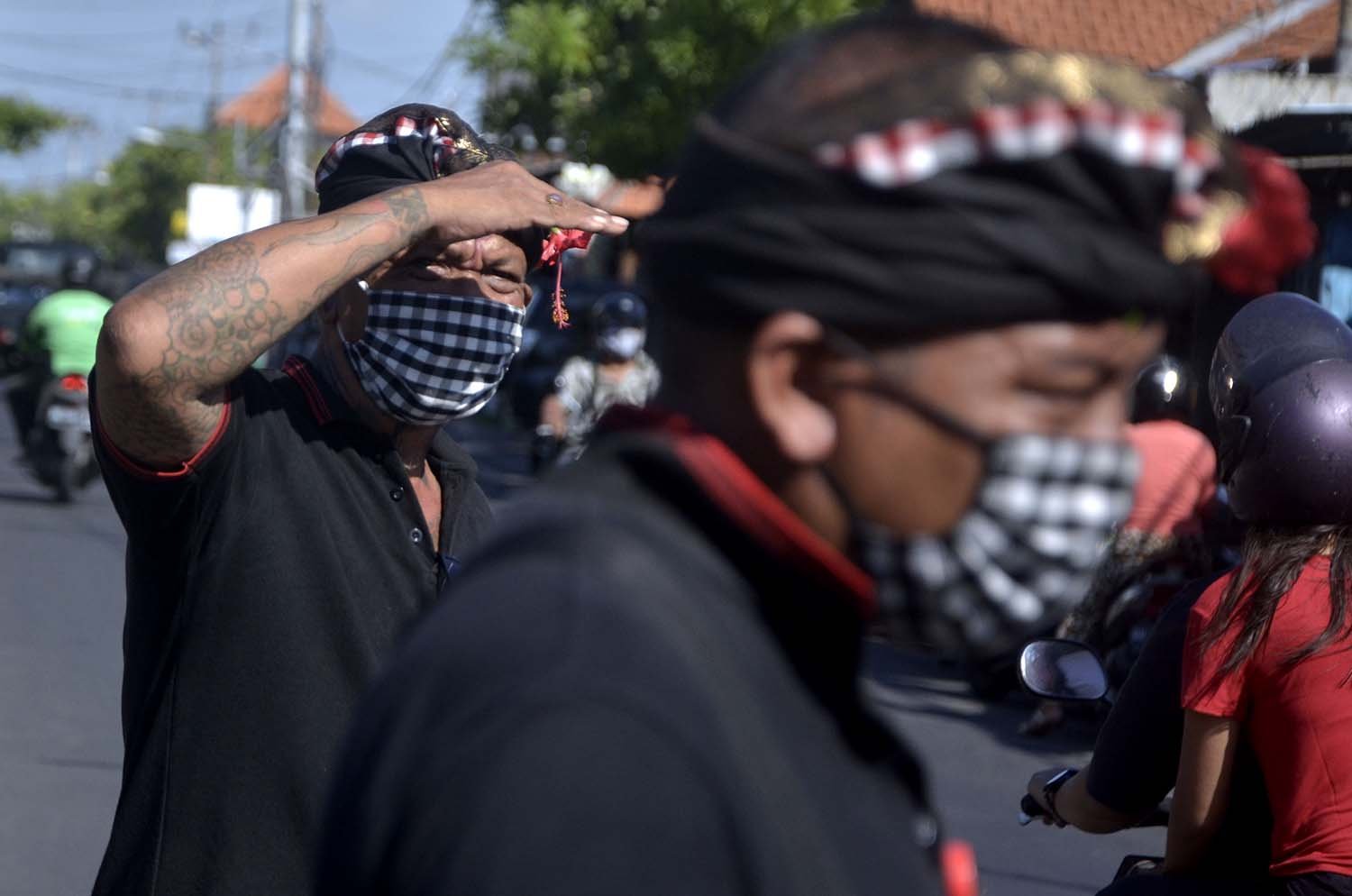 Pecalang memantau aktivitas warga saat kegiatan sosialisasi dan edukasi pendisiplinan penggunaan masker di wilayah Desa Adat Intaran, Sanur, Denpasar.