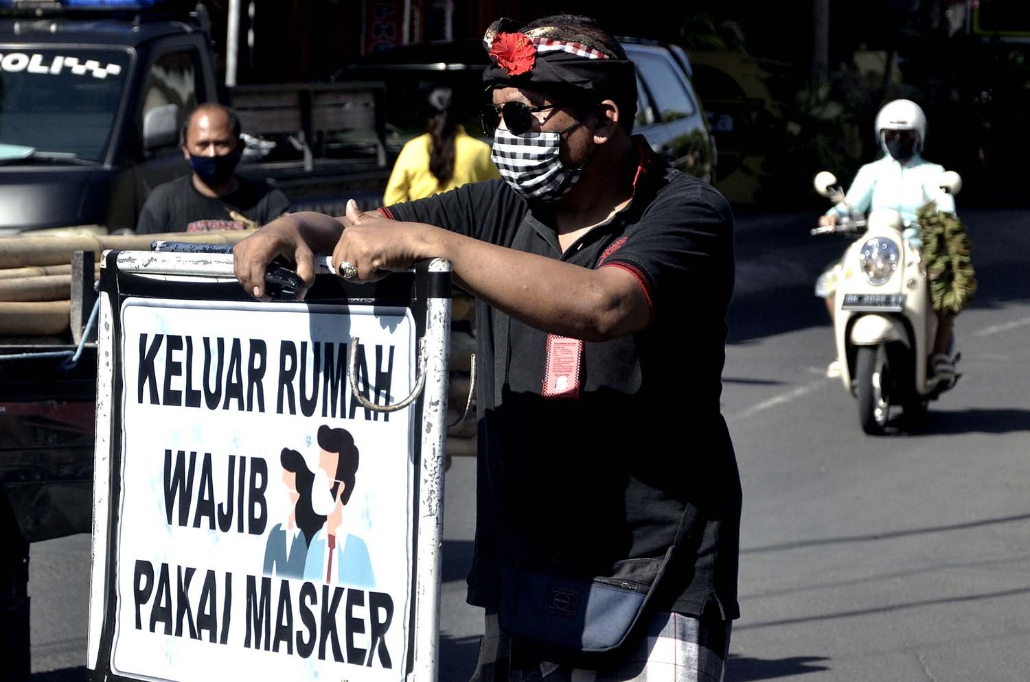 Pecalang atau petugas keamanan adat Bali berjaga saat kegiatan sosialisasi dan edukasi pendisiplinan penggunaan masker di wilayah Desa Adat Intaran, Sanur.