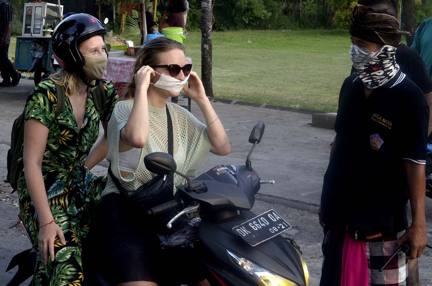 Pecalang meminta wisatawan mancanegara untuk mengenakan masker sebagai upaya pencegahan penyebaran COVID-19 di wilayah Desa Adat Jimbaran, Badung.