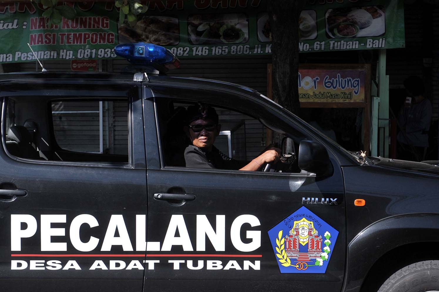 Pecalang atau petugas keamanan adat Bali melakukan patroli untuk memastikan ketertiban masyarakat terkait aturan pencegahan penyebaran COVID-19 di wilayah Desa Adat Tuban, Badung.