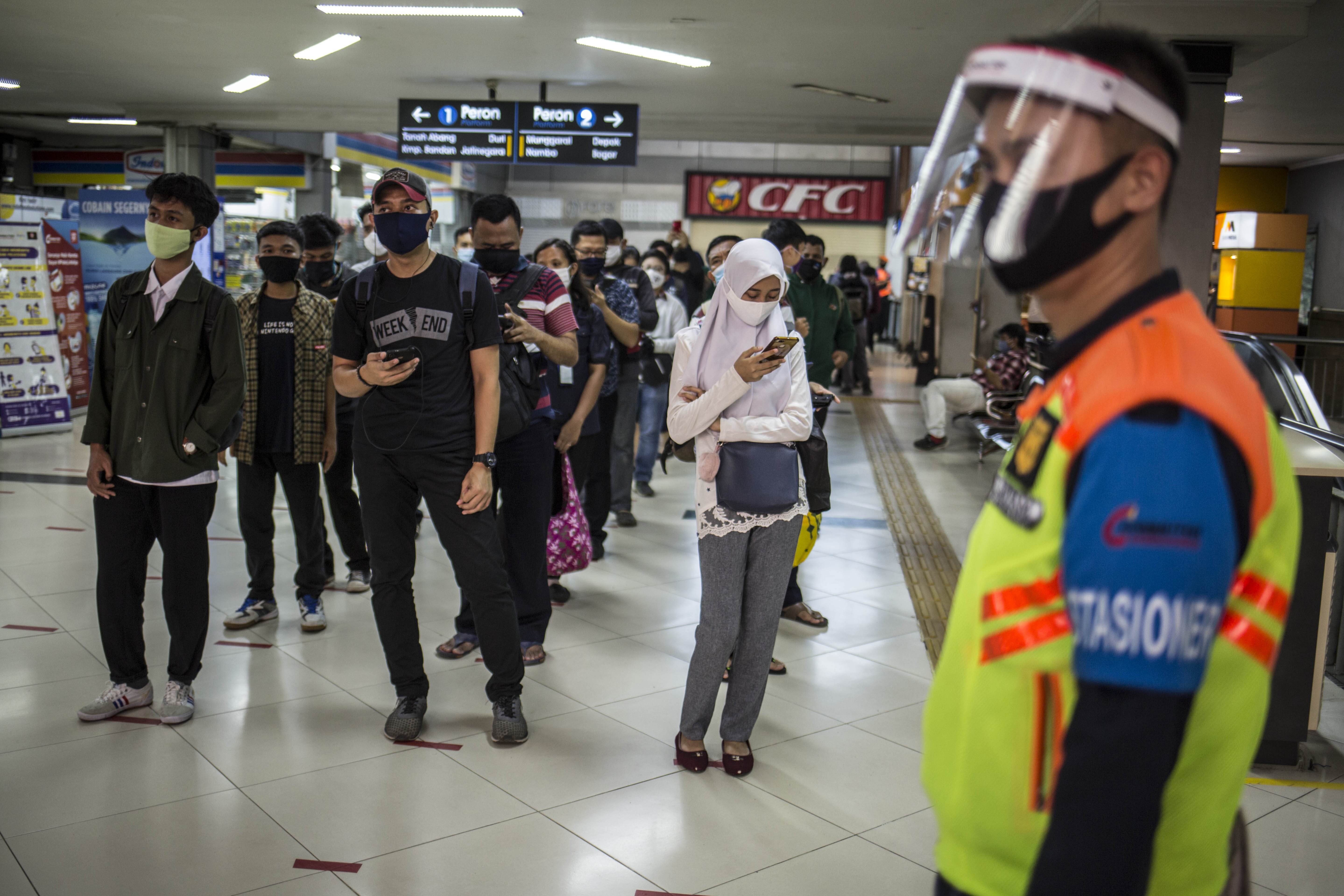 Sejumlah penumpang saat menunggu giliran menaiki KRL di Stasiun Sudirman, Jakarta Pusat, Senin (8/6/2020). Lonjakan penumpang terjadi saat hari pertama dimulainya aktifitas perkantoran di Jakarta pada masa transisi Pembatasan Sosial Bersekala Besar (PSBB).