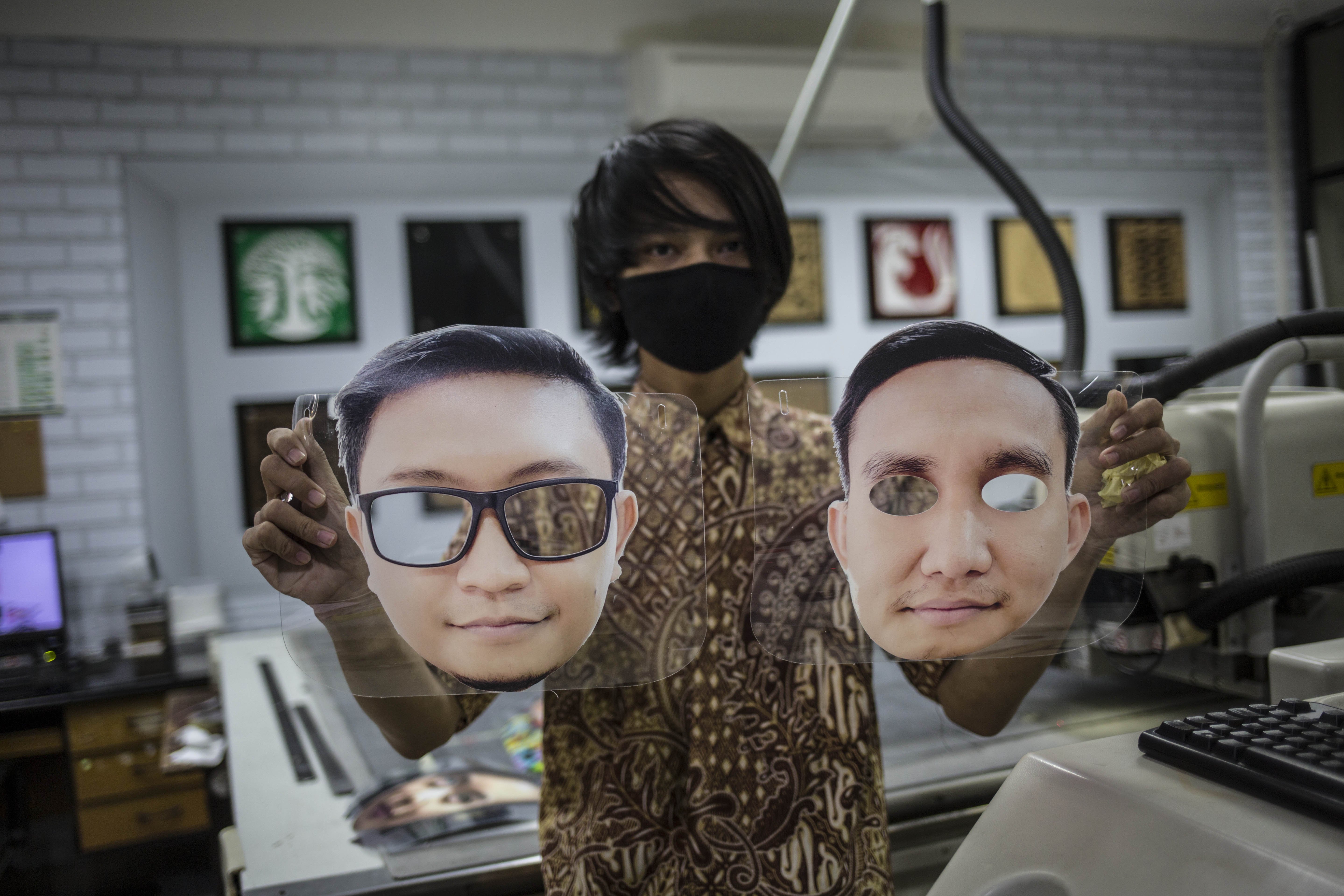 Pekerja menujukan pelindung wajah berkarakter di percetakan Bintang Sempurna, Bendungan Hilir, Jakarta Pusat, Jumat (20/6/2020).