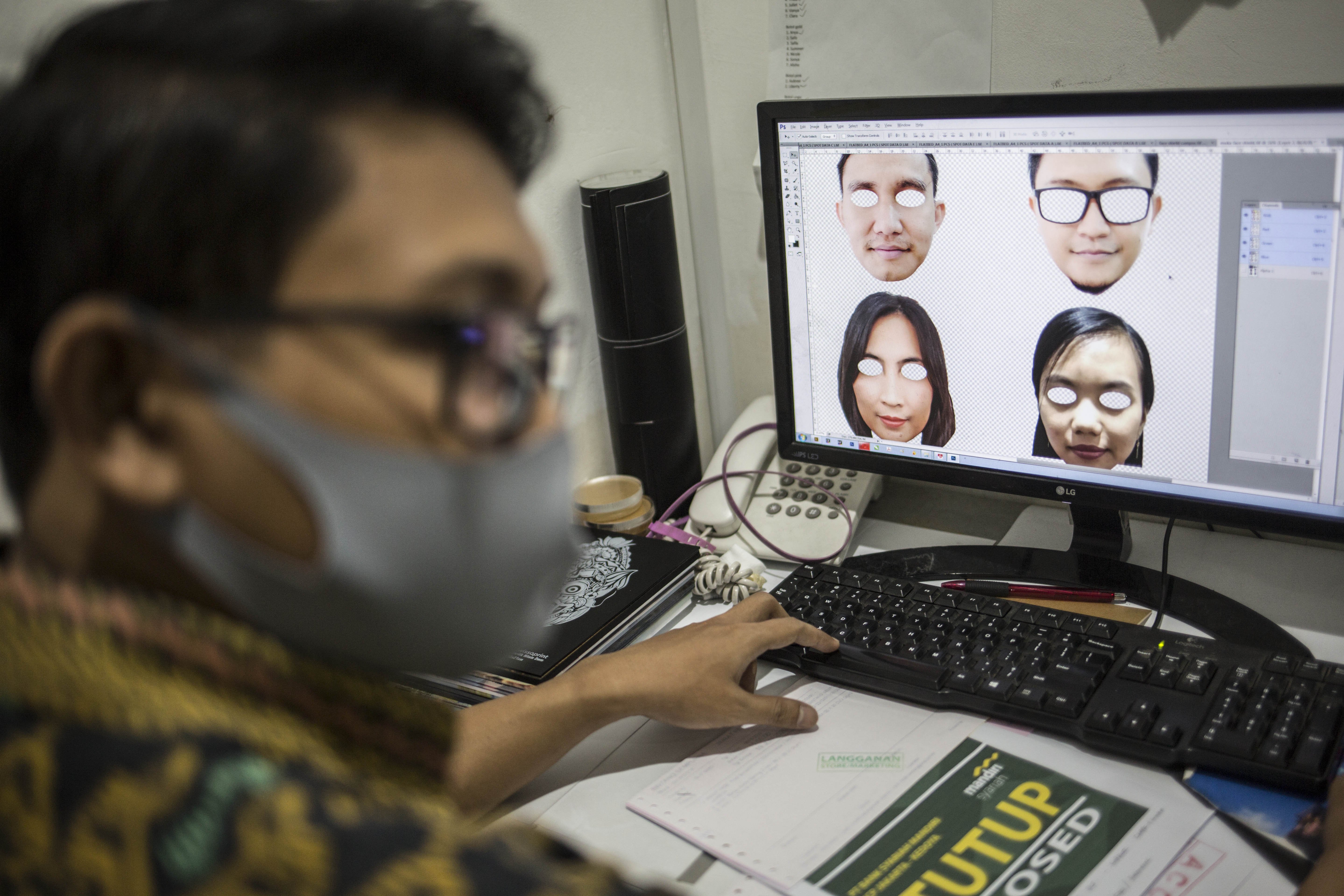 Pekerja menyelesaikan desain pelindung wajah berkarakter di percetakan Bintang Sempurna, Bendungan Hilir, Jakarta Pusat, Jumat (19/6/2020).
