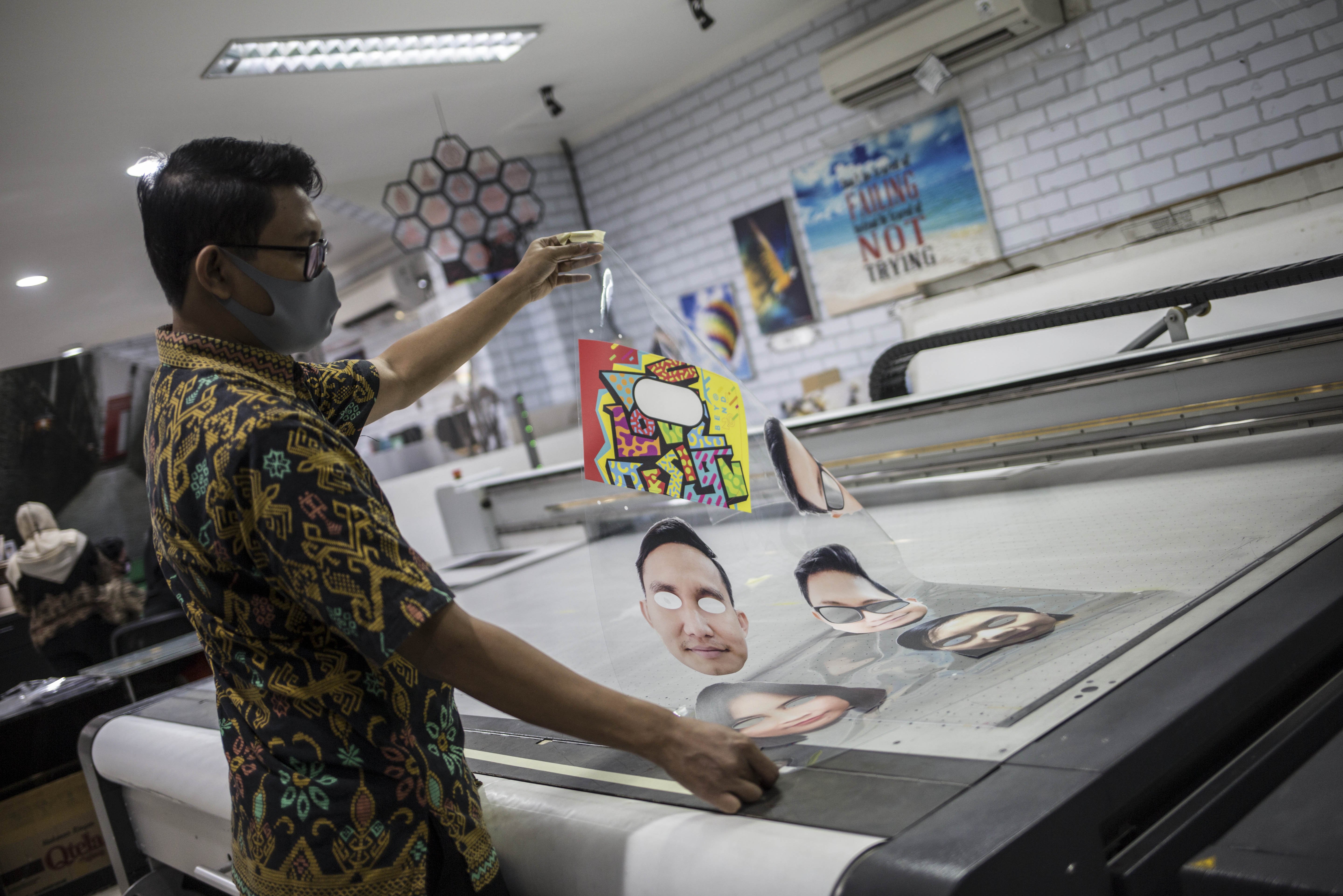 Pekerja menyelesaikan produksi pelindung wajah berkarakter di percetakan Bintang Sempurna, Bendungan Hilir, Jakarta Pusat, Jumat (19/6/2020).