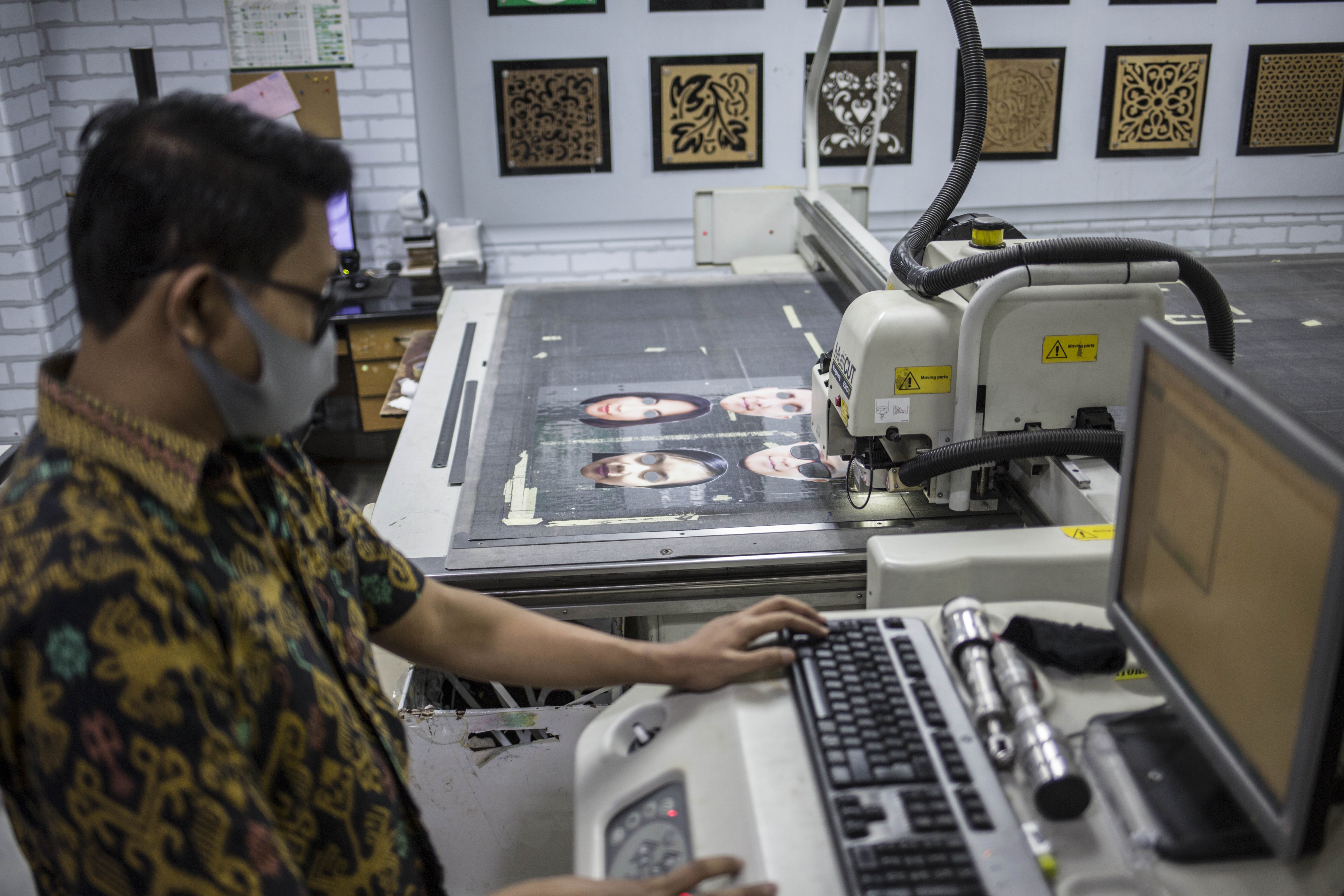 Pekerja menyelesaikan produksi pelindung wajah berkarakter di percetakan Bintang Sempurna, Bendungan Hilir, Jakarta Pusat, Jumat (19/6/2020).