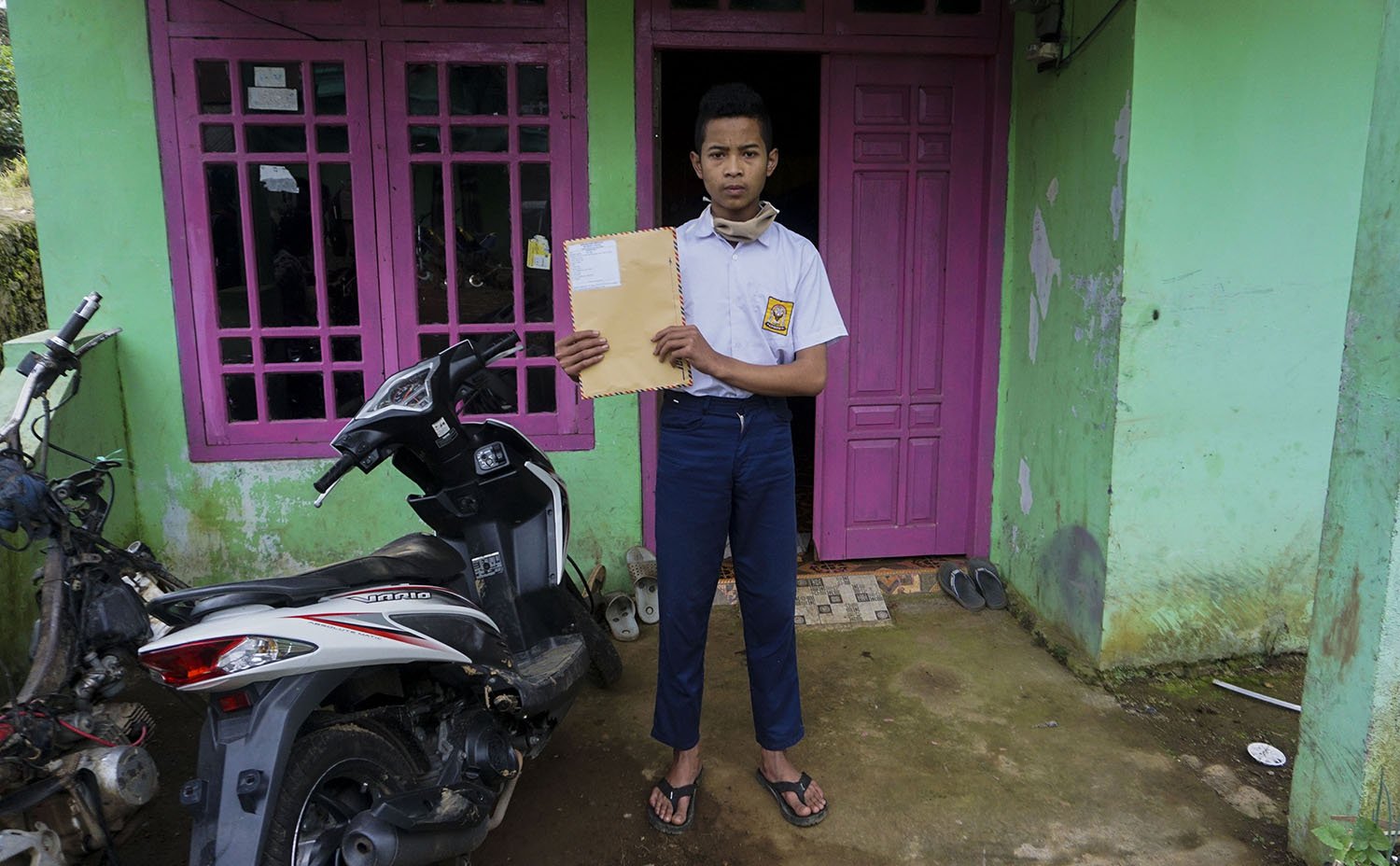 Pelajar SMP N 4 Bawang, Khoerul Risal, menunjukkan amplop berkas lembar tugas yang diantarkan langsung oleh gurunya di Pranten, Kecamatan Bawang, Kabupaten Batang, Jawa Tengah.