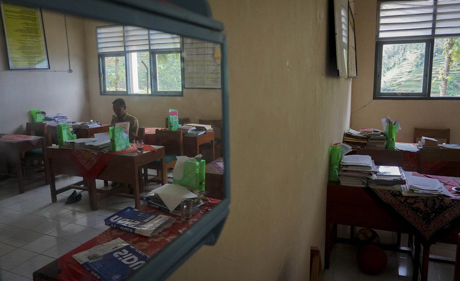 Kepala Sekolah SMP N 4 Bawang Mulud Sugito mengoreksi tugas sekolah siswa di SMP N 4 Bawang di Pranten, Kecamatan Bawang, Kabupaten Batang, Jawa Tengah.