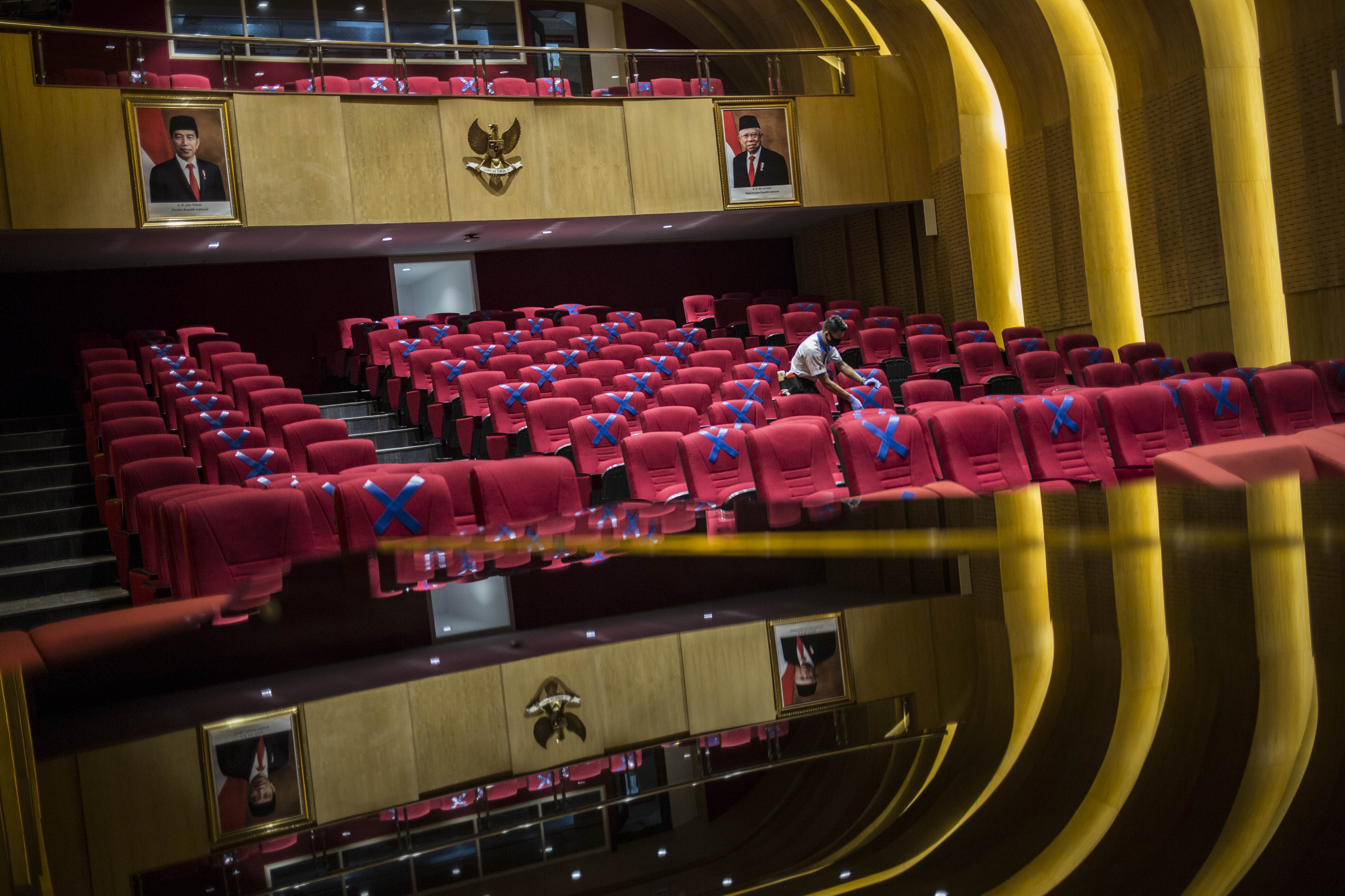 Petugas memasang tanda berjaga jarak di Perpusnas, Jakarta Pusat.