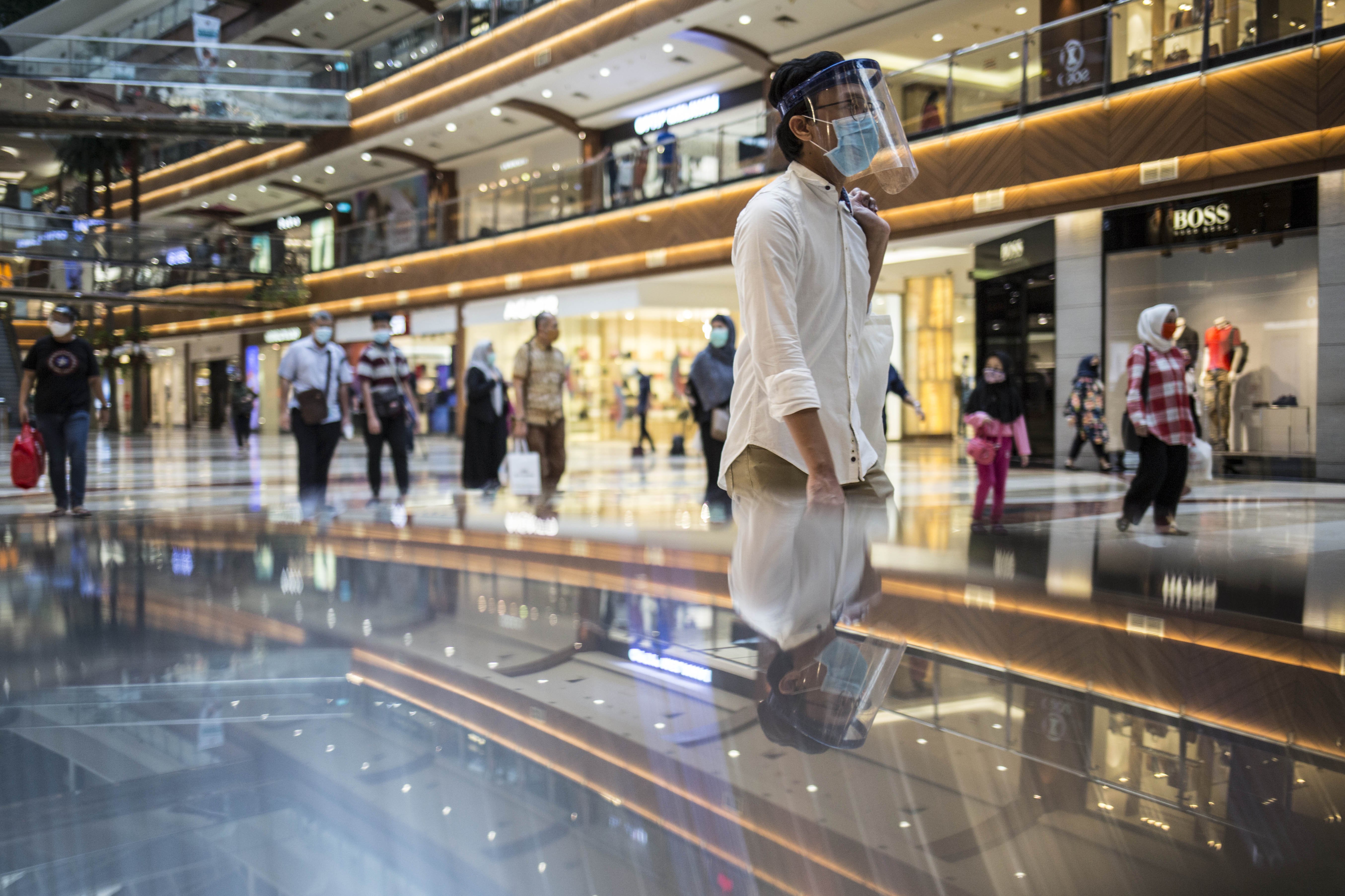 Pengunjung menggunakan pelindung wajah saat berbelanja di Pondok Indah Mall, Jakarta.