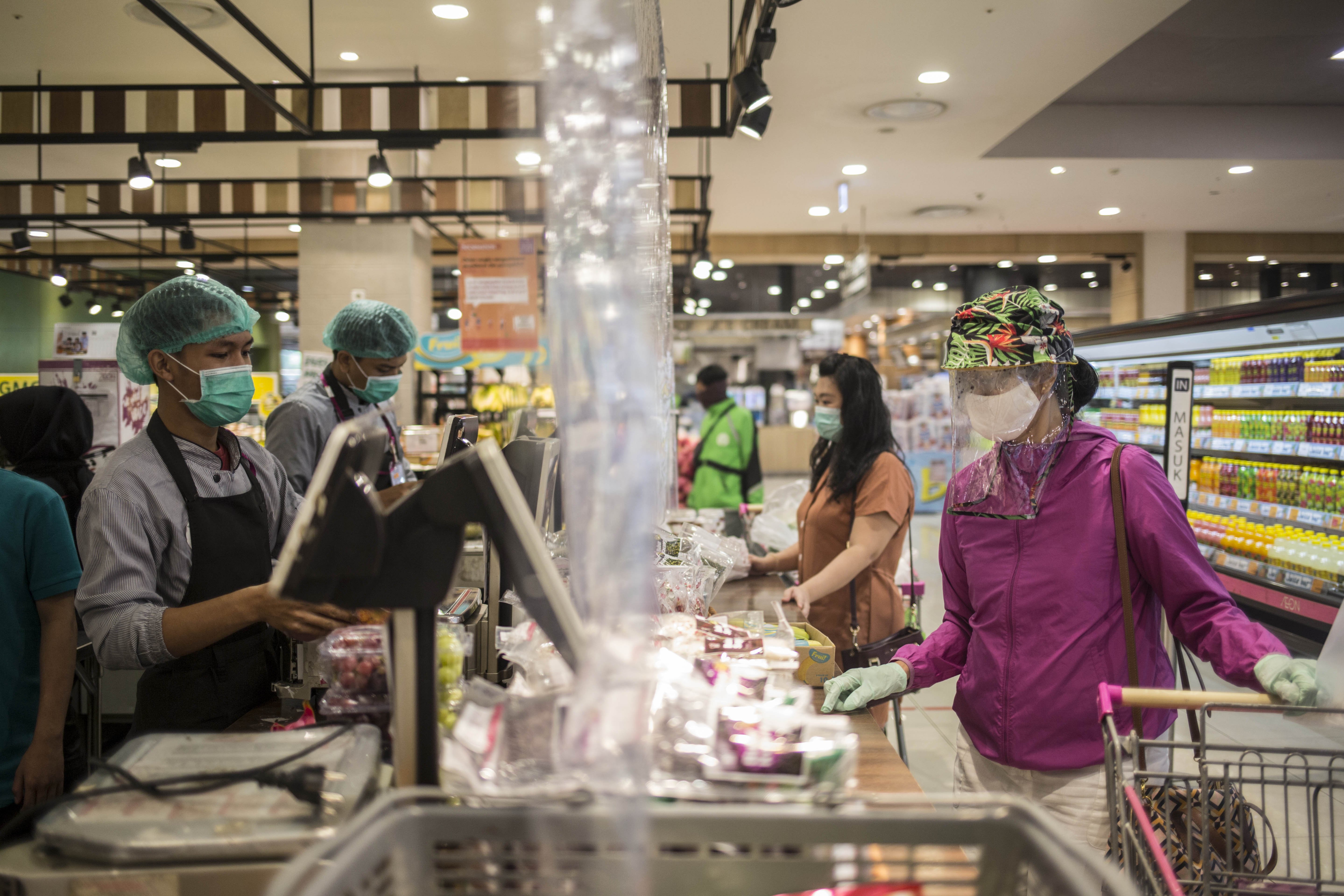 Warga berbelanja dengan menggunakan pelindung wajah di mall kawasan Tangerang.