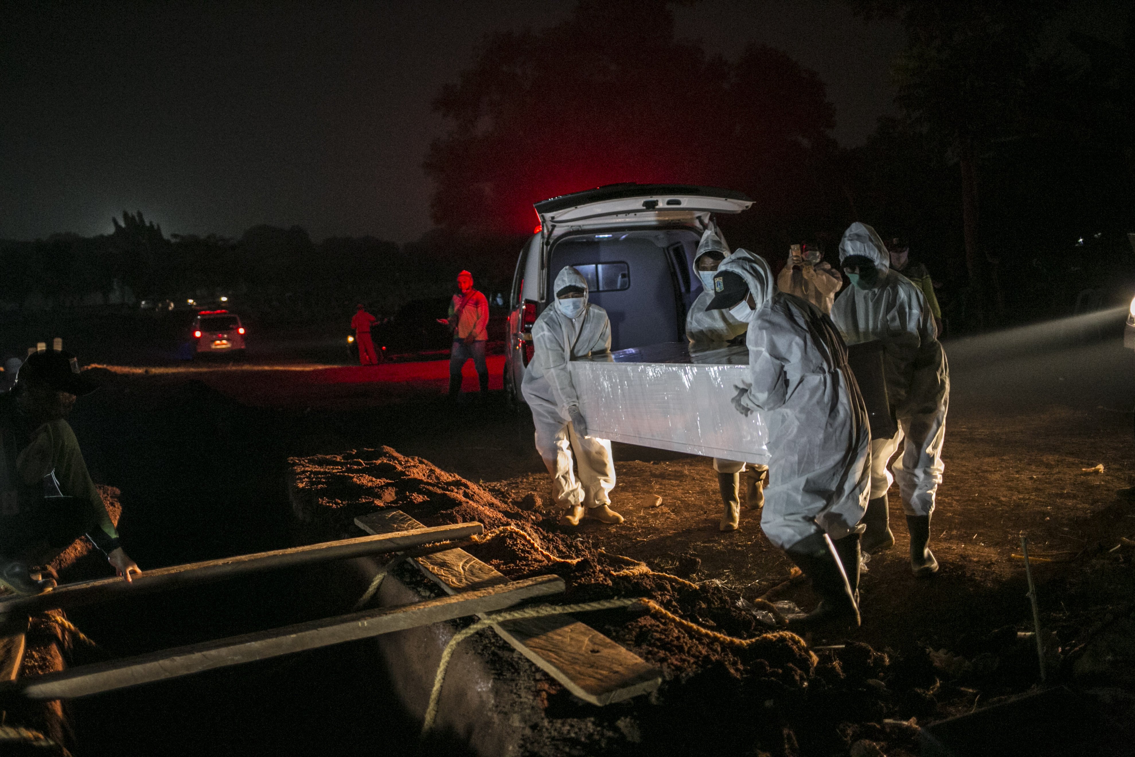 Petugas menggunakan Alat Pelindung Diri (APD) memakamkan jenazah covid-19 di TPU Pondok Rangon, Jakarta, Kamis (16/7/2020).