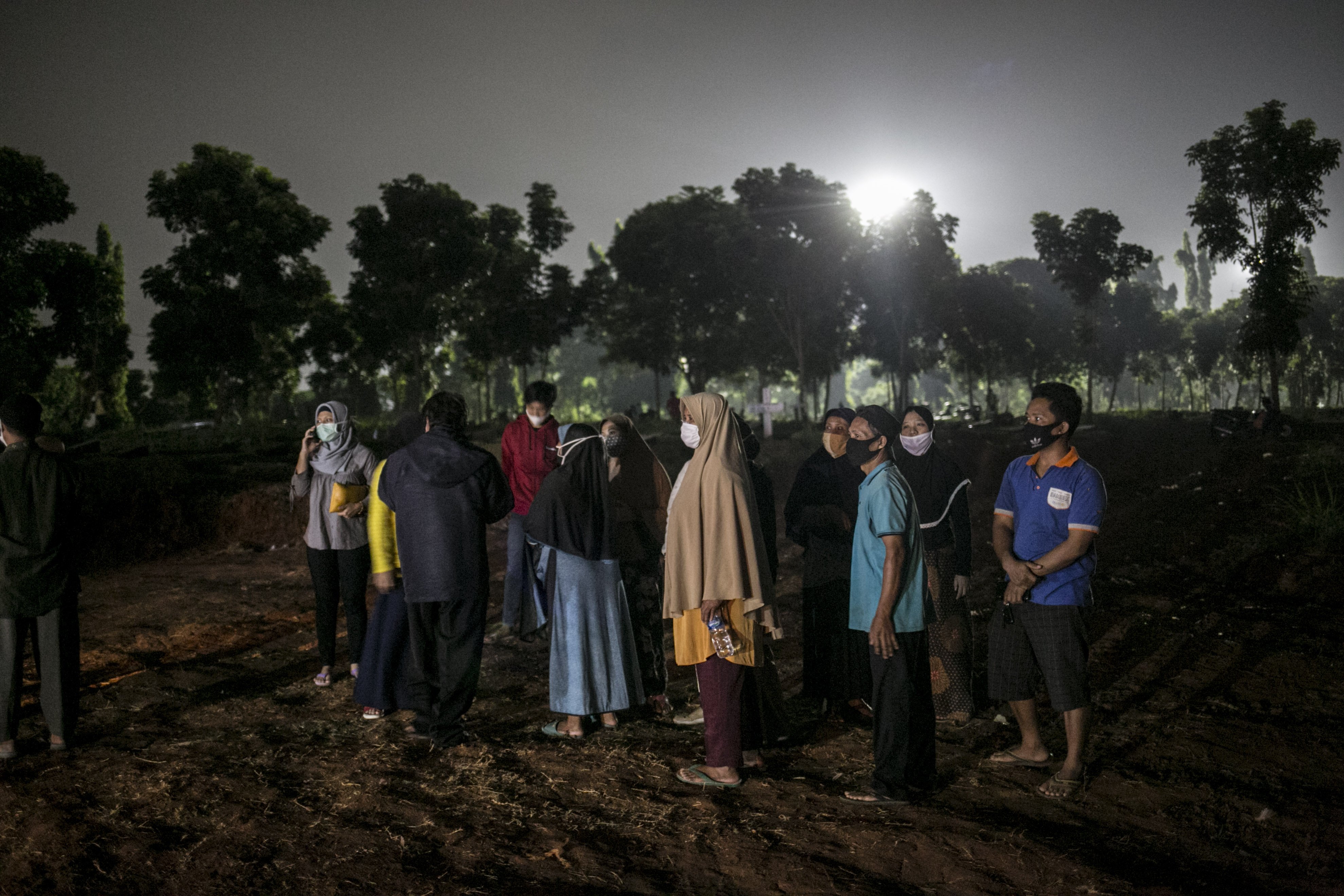 Keluarga korban covid-19 menyaksikan pemakaman di TPU Pondok Rangon, Jakarta, Kamis (16/7/2020).