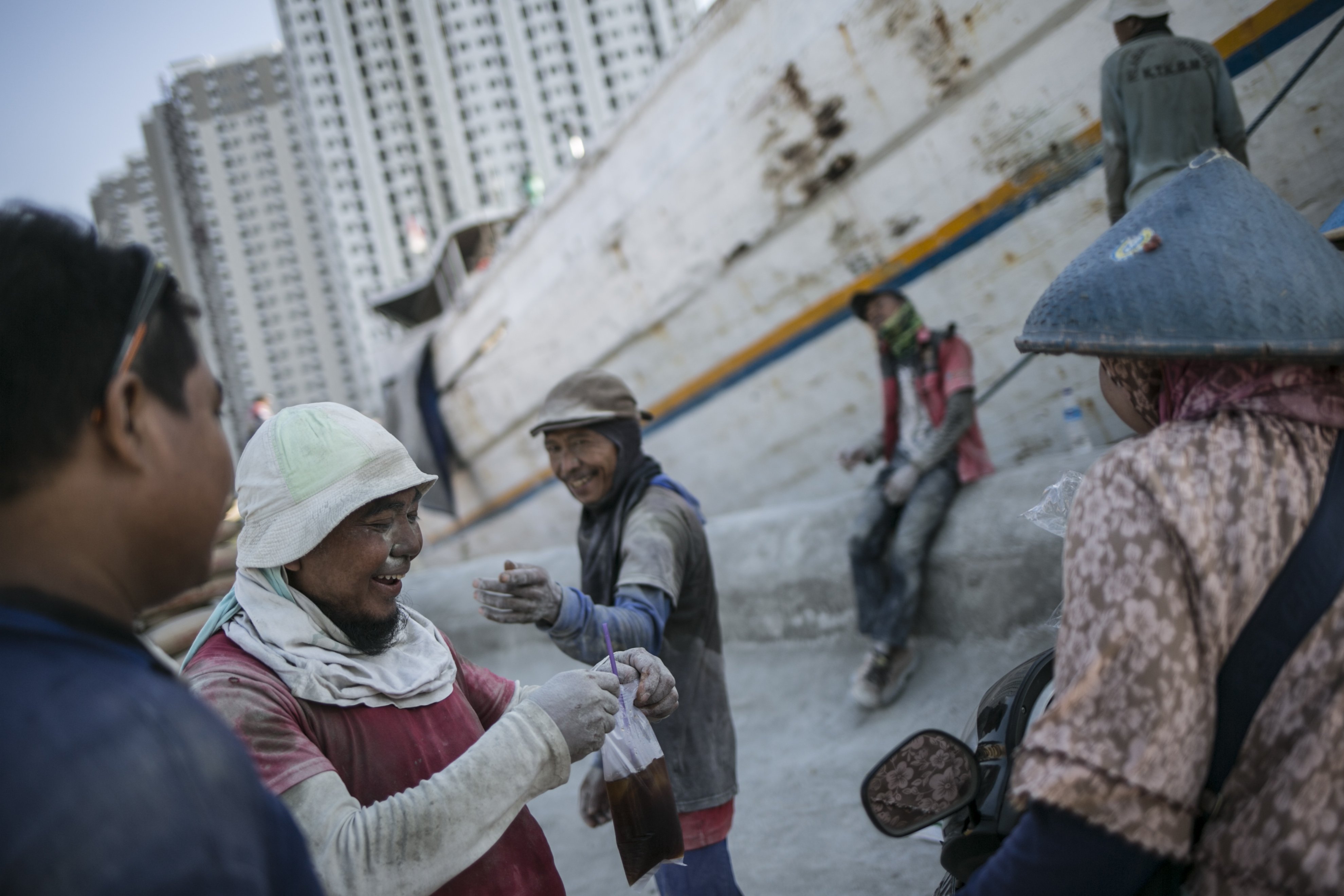 Para pekerja angkut barang membeli minuman dan beristirahat di sela-sela pekerjaan di Pelabuhan Sunda Kelapa, Jakarta Utara, Senin (27/7/2020). Aktivitas di Pelabuhan Sunda Kelapa berangsur normal seperti biasa walaupun di tengah pandemi virus Corona (COVID-19).