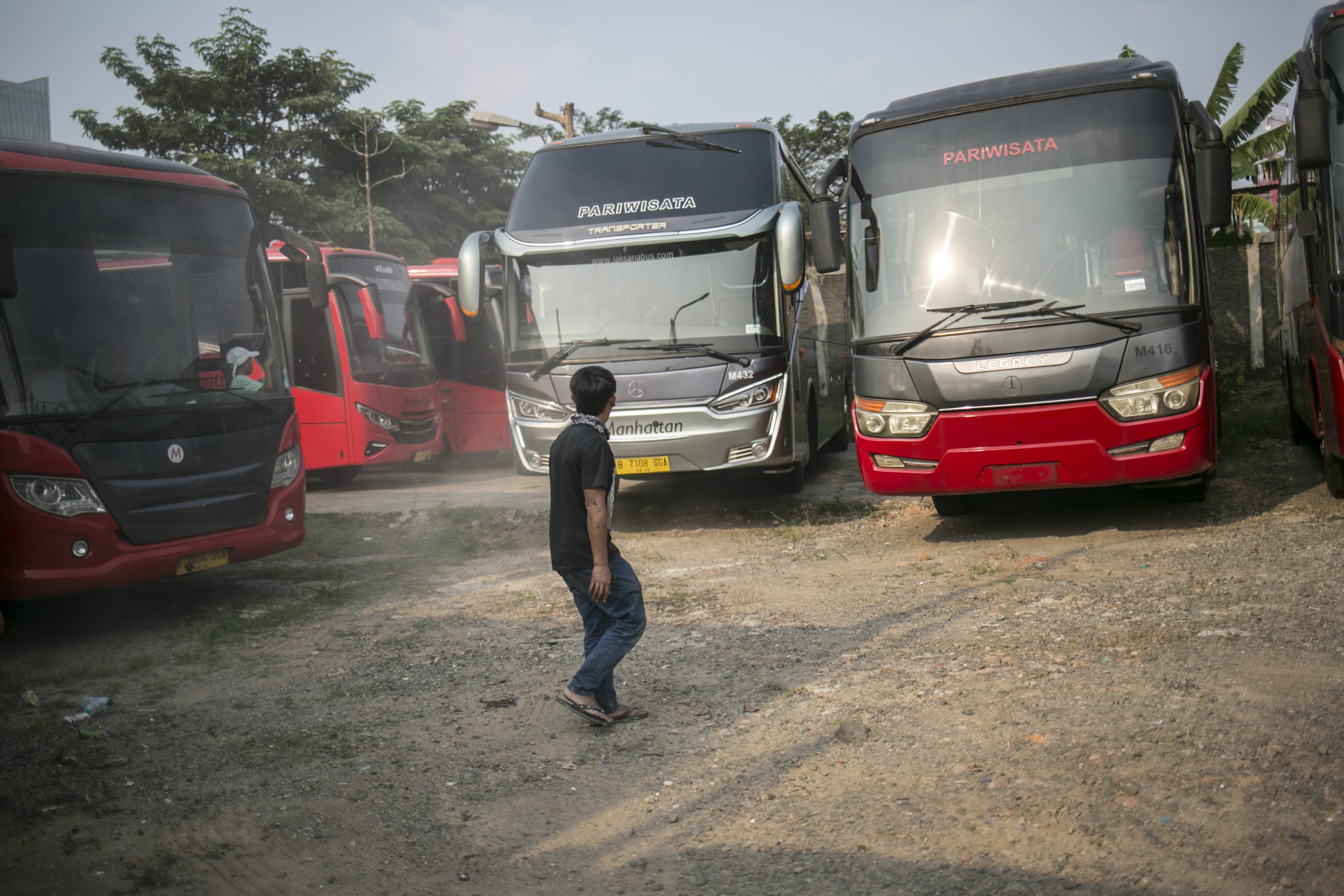 Sejumlah bus terparkir di salah satu pool bus pariwisata di kawasan Tanjung Barat, Jagakarsa, Jakarta, Selasa (28/7/2020). Masih diberlakukannya Pembatasan Sosial Bersekala Besar (PSBB) dan penutupan tempat rekreasi akibat Covid-19, berimbas pada jasa transportasi pariwisata. Sejak bulan Maret pengelola mengaku mengalami penurunan pendapatan dan penyewaan bus hingga 80%.