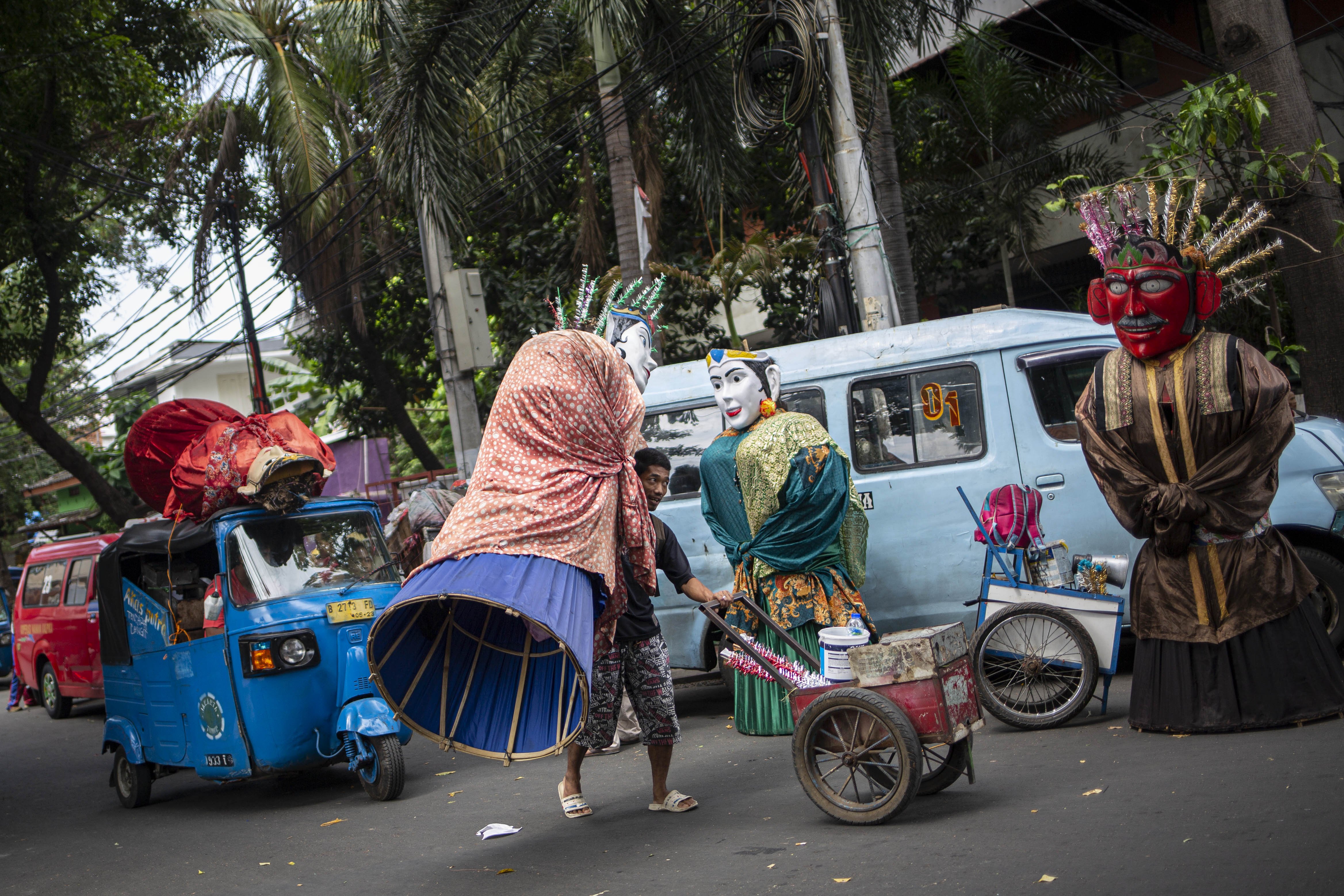 Pegiat seni jalanan boneka ondel-ondel melintas di Jalan Kembang Pacar, Kramat Pulo, Senen, Jakarta Pusat, Rabu (12/8/2020).
