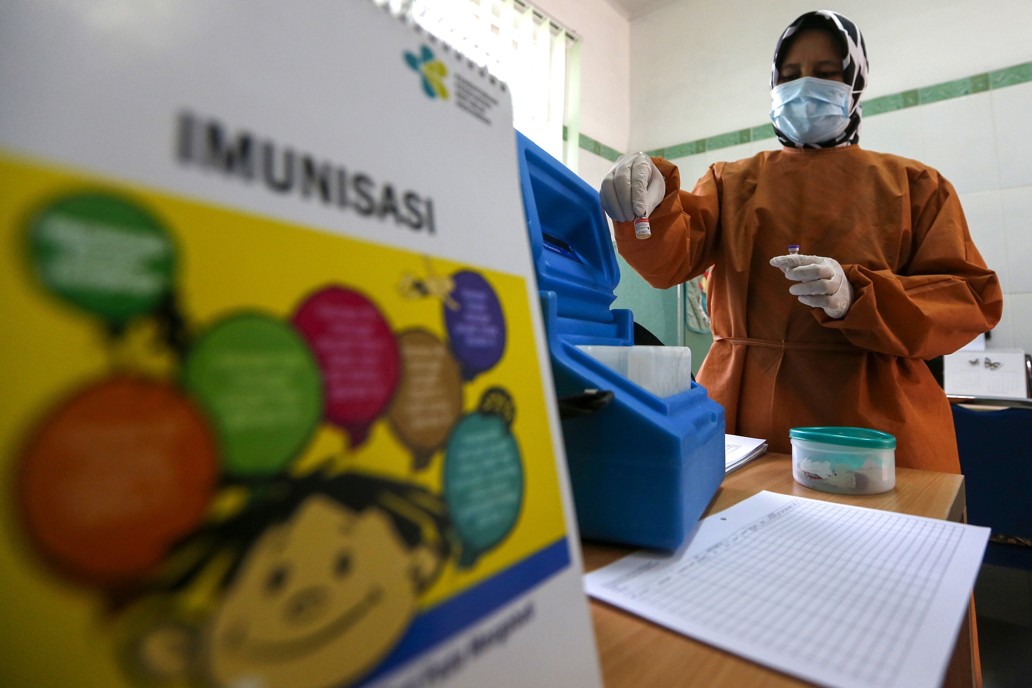 Petugas kesehatan Puskesmas Kopelma Darussalam mempersiapkan vaksin imunisasi sebelum mendatangi para balita secara langsung di rumah mereka di Desa Rukoh, Banda Aceh, Aceh, Rabu (7/10/2020).