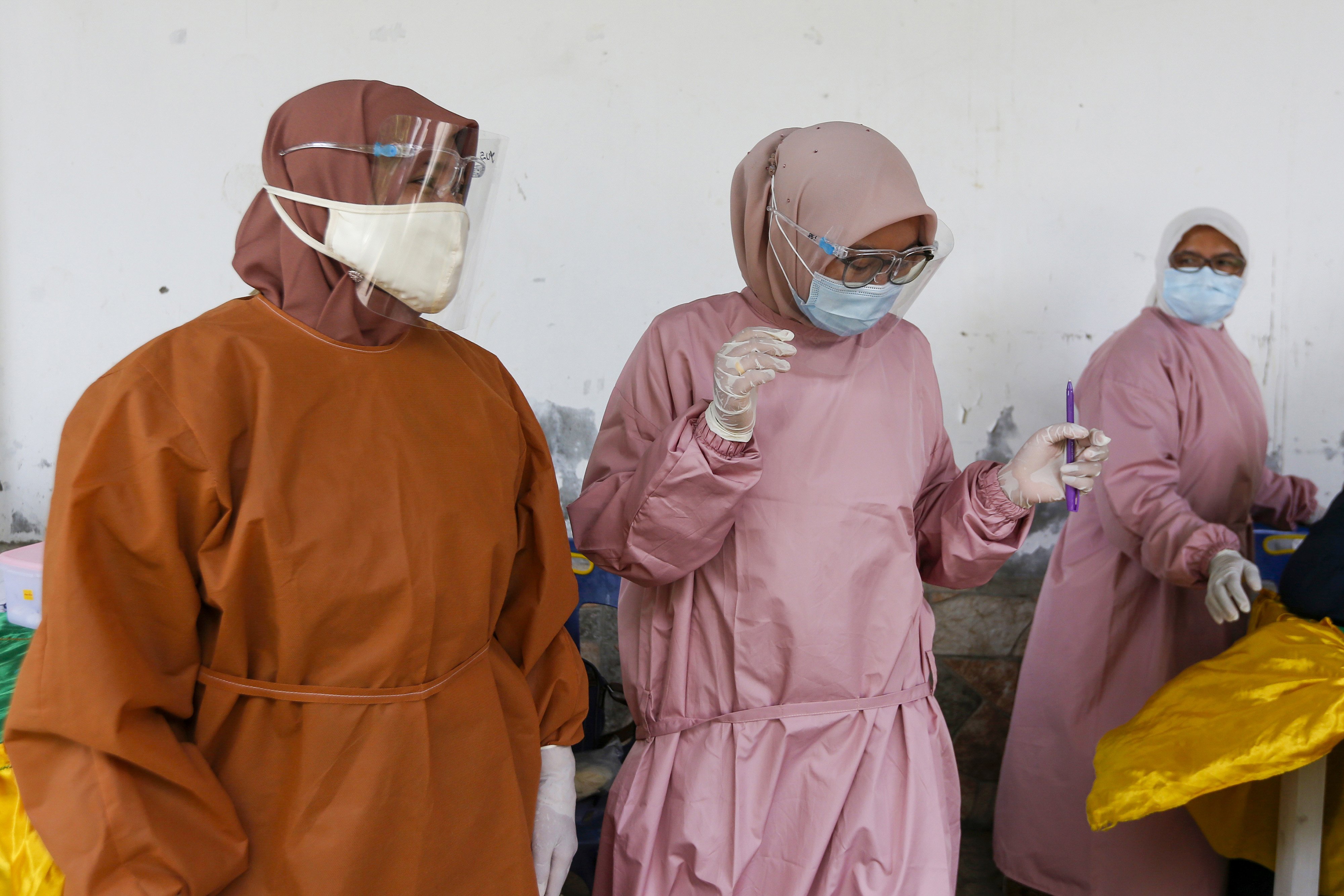 Petugas kesehatan Puskesmas Kopelma Darussalam mengenakan alat pelindung diri (APD) guna mencegah penularan COVID-19 sebelum melakukan imunisasi dengan cara mendatangi para balita secara langsung di rumah mereka di Desa Ie Masen Kaye Adang, Banda Aceh, Aceh, Sabtu (15/10/2020). 