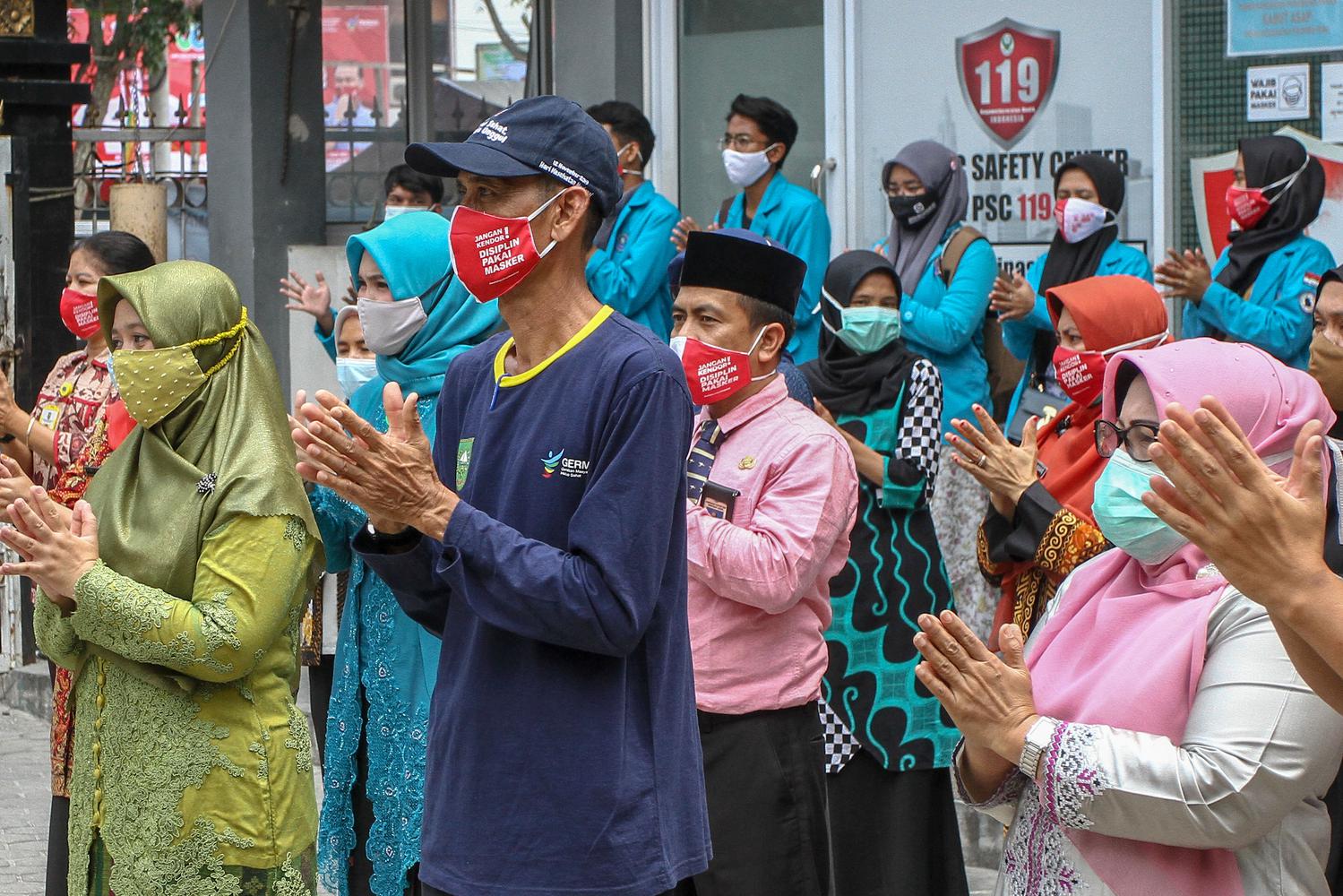 Pegawai Dinas Kesehatan Provinsi Riau bersama komunitas relawan peduli kesehatan bertepuk tangan selama 56 detik di halaman Kantor Dinkes Provinsi Riau di Pekanbaru, Riau, Kamis (12/11/2020). Selain untuk memperingati Hari Kesehatan Nasional ke-56, kegiatan tersebut juga sebagai bentuk apresiasi serta dukungan terhadap para seluruh petugas yang berjuang melawan COVID-19 dan juga kepada masyarakat yang telah melaksanakan protokol kesehatan.