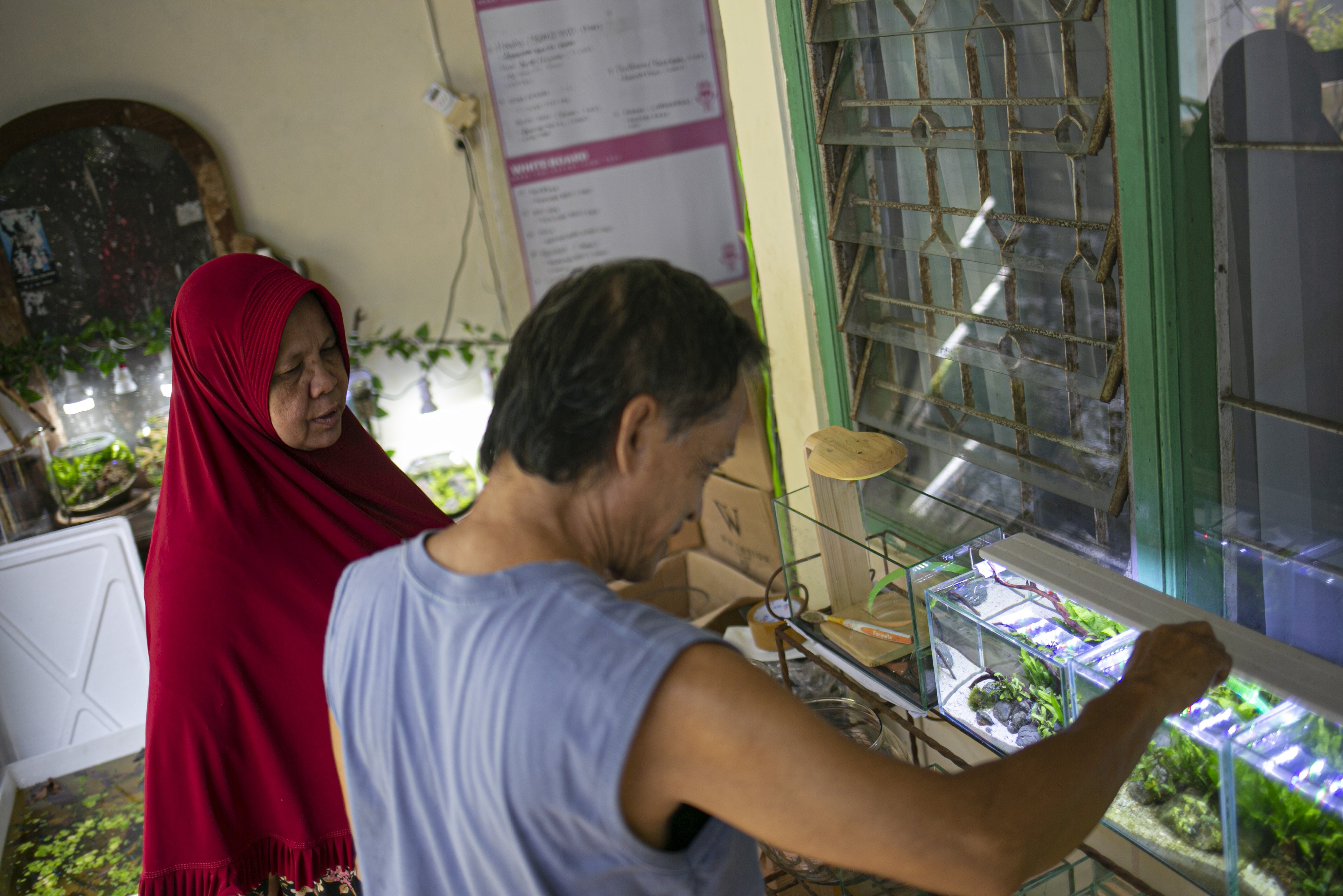 Iskandar (63), menyelesaikan pembuatan aquascape mini di Ciputat, Tangerang Selatan, Jumat (13/11).
