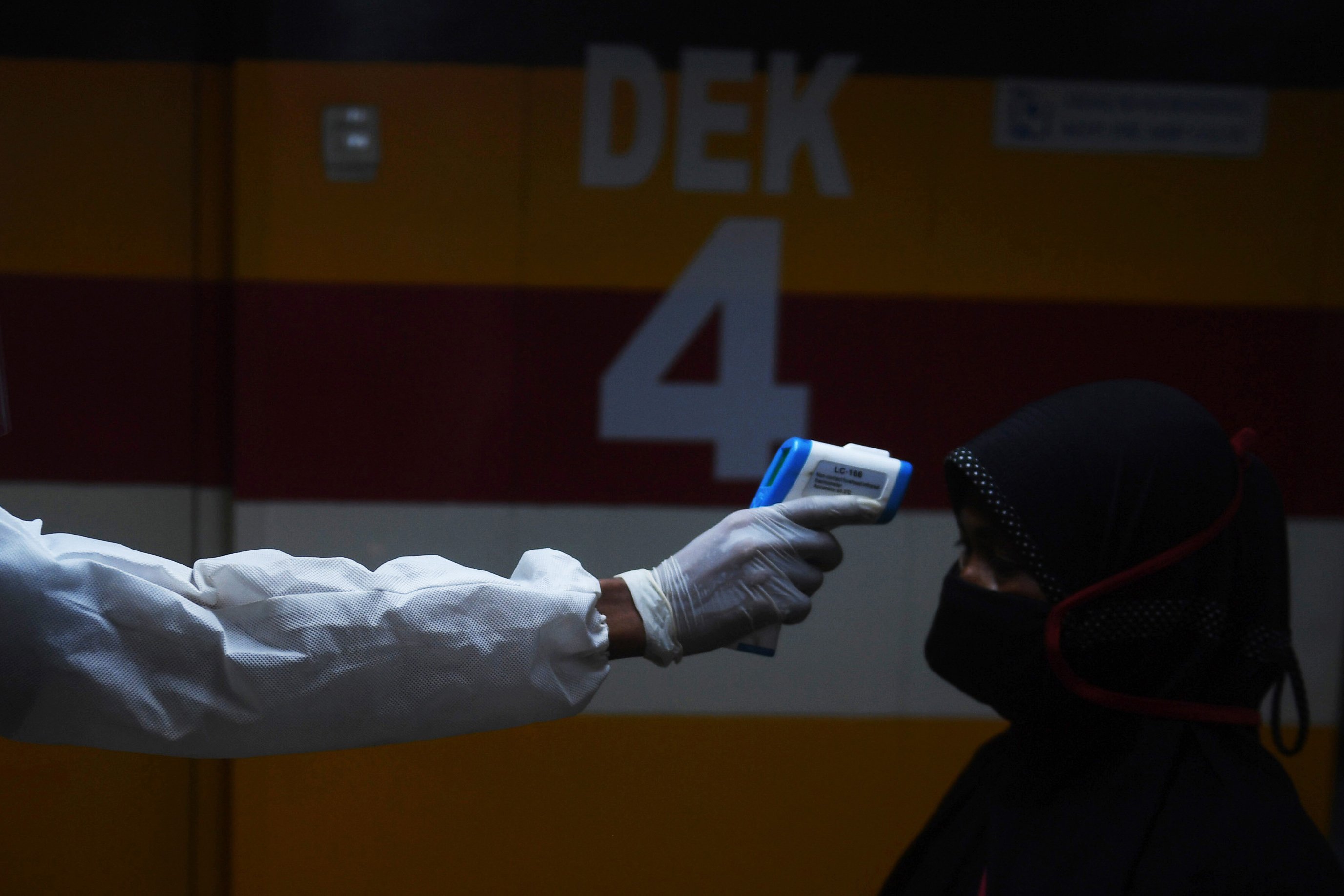 Petugas memeriksa suhu penumpang sebelum menaiki KM Dorolonda yang akan diberangkatkan dari Terminal Penumpang Tanjung Priok, Jakarta.